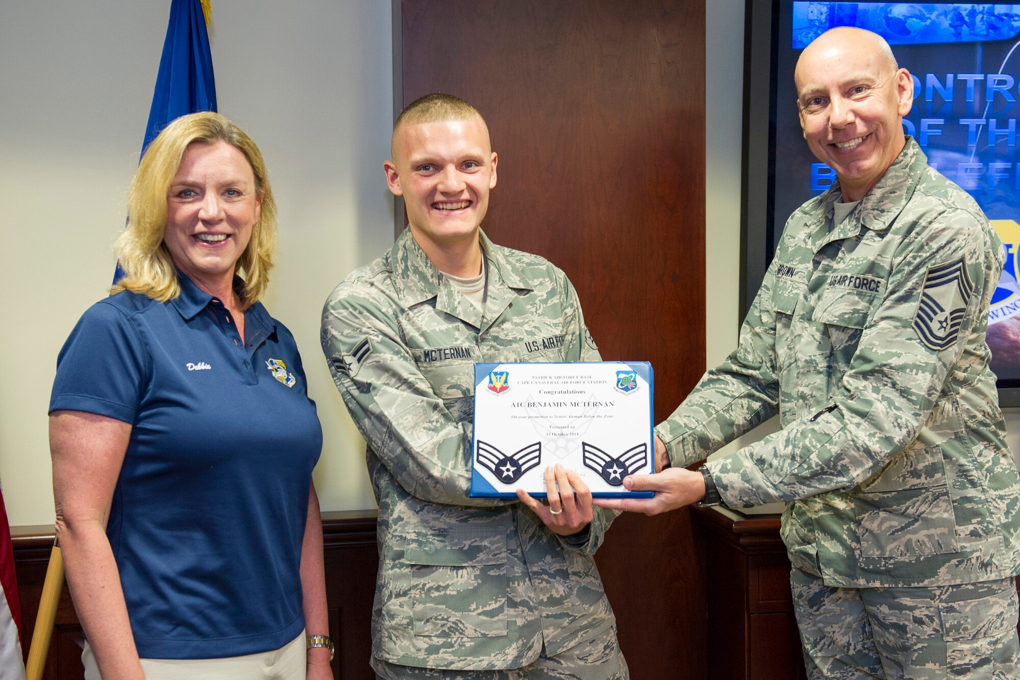 Secretary of the Air Force Deborah Lee James and Chief Master Sgt. Matthew Brown, Air Force Technical Applications Center Command Chief, present a ‘Below the Zone’ promotion award to Airman 1st Class Benjamin McTernan, of AFTAC, at Patrick Air Force Base and Cape Canaveral Air Force Station, Fla., Oct. 15, 2014.  The Secretary’s daylong visit included meeting Airmen assigned to the two installations as well as tours of Air Force Eastern Range launch assets and a windshield tour of NASA’s Kennedy Space Center. (U.S. Air Force photo/Matthew Jurgens)