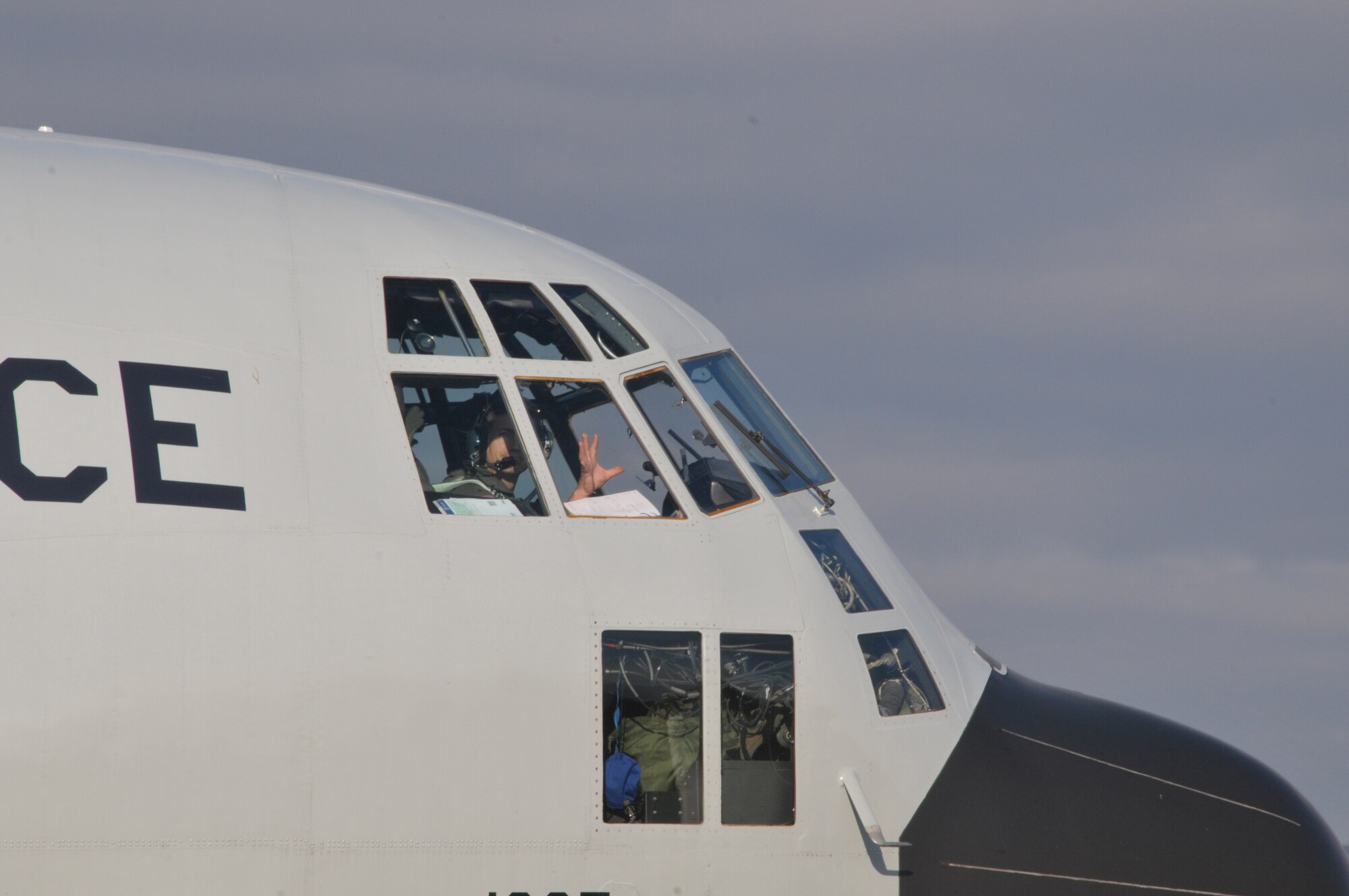 Maj. Joshua Hicks, co-pilot, waves goodbye from inside the cockpit of an LC-130 Hercules headed for Antarctica. The 109th Airlift Wing aircraft and crew took off from Stratton Air National Guard Base, Scotia, New York, on Oct. 17, 2014. The aircraft is headed to Antarctica for the Wing's 27th year participating in Operation Deep Freeze in support of the National Science Foundation. The 109th AW boasts the U.S. military's only ski-equipped aircraft, which has been supporting the NSF's South Pole research since 1988. (U.S. Air National Guard photo by Master Sgt. William Gizara/Released)
