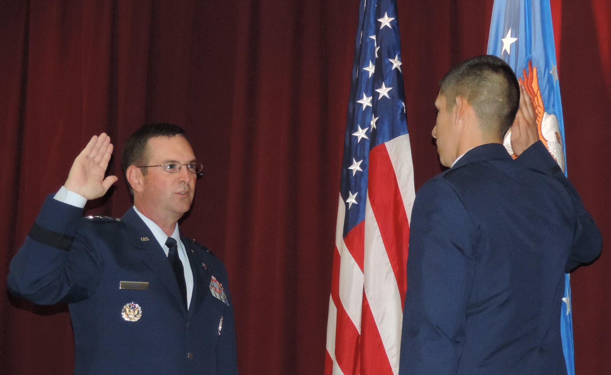 At a commissioning ceremony for the Academy of Military Science at Maxwell Air Force Base, Ala., Lt. Gen. Joseph L. Lengyel administers the state oath of office to Officer Candidate Adam L. Bernal.  With this ceremony, Fountain became a second lieutenant in the Texas Air National Guard and the United States Air Force. This is unique for National Guard members where they swear to obey the orders of the President of the United States and their respective Governor. (Air National Guard photo by Col. Nahaku A. McFadden)