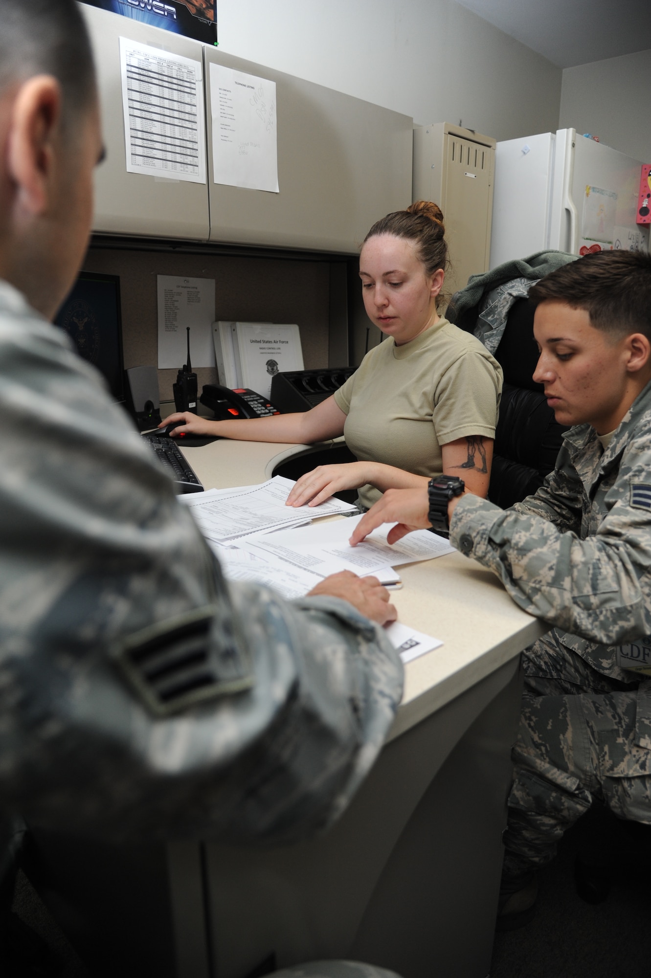 Senior Airman Christopher Emond, Staff Sgt. Ann Yarbrough and Senior Airman Anna Martin, 81st Logistics Readiness Squadron, check shipment information into the cargo movement operations system at the supply warehouse during a humanitarian deployment exercise Oct. 15, 2014, at the Taylor Logistics Center, Keesler Air Force Base, Miss.  The exercise scenario tested the mission readiness of Team Keesler members for world-wide deployments. (U.S. Air Force photo by Kemberly Groue)