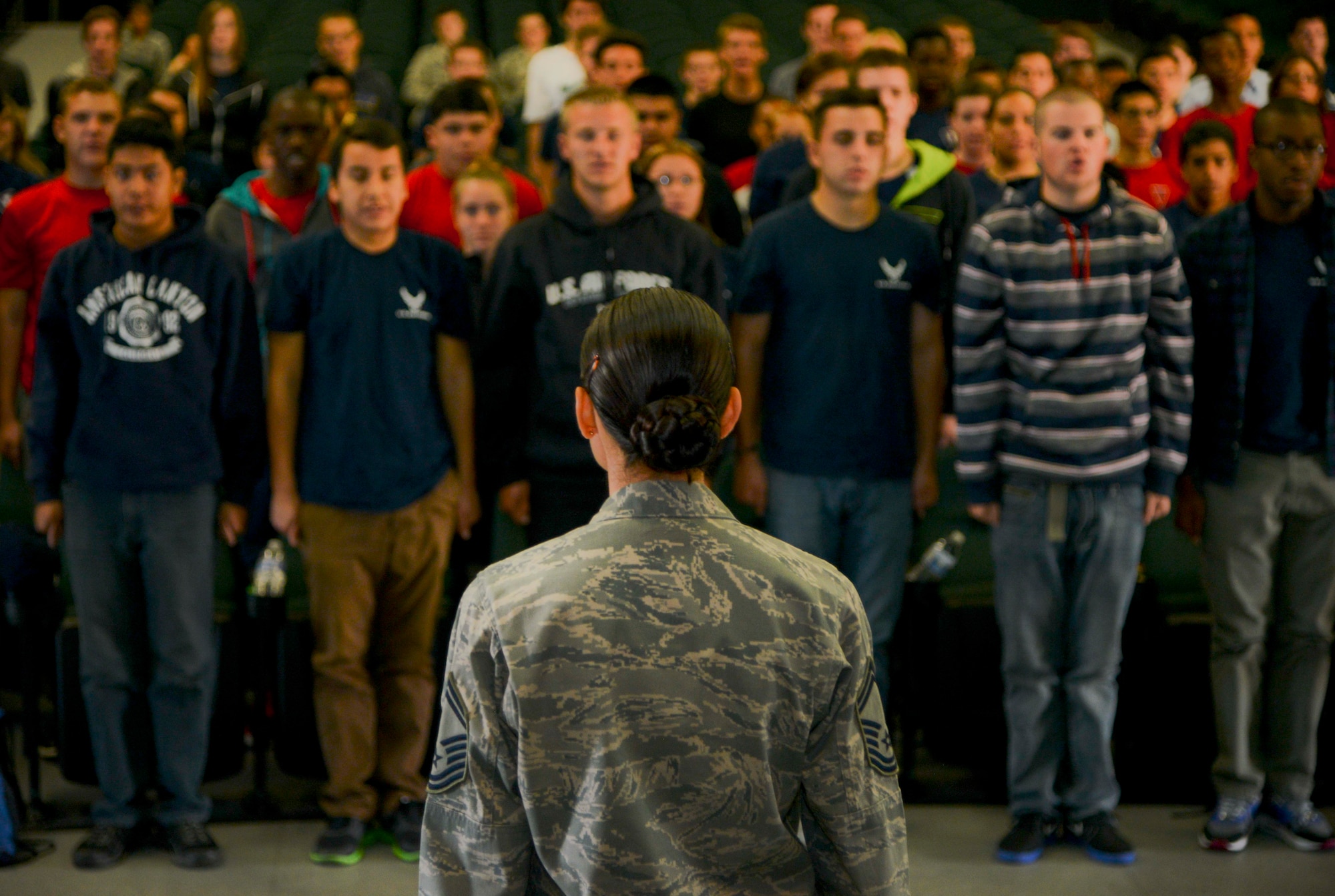 Senior Master Sgt. Hope Skibitsky, 60th Force Support Squadron career assistance adviser and former military training instructor, brings a room of recruits to attention Oct. 10, 2014, after giving them a dose of what to expect in basic military training. (U.S. Air Force photo by Senior Airman Madelyn Brown)