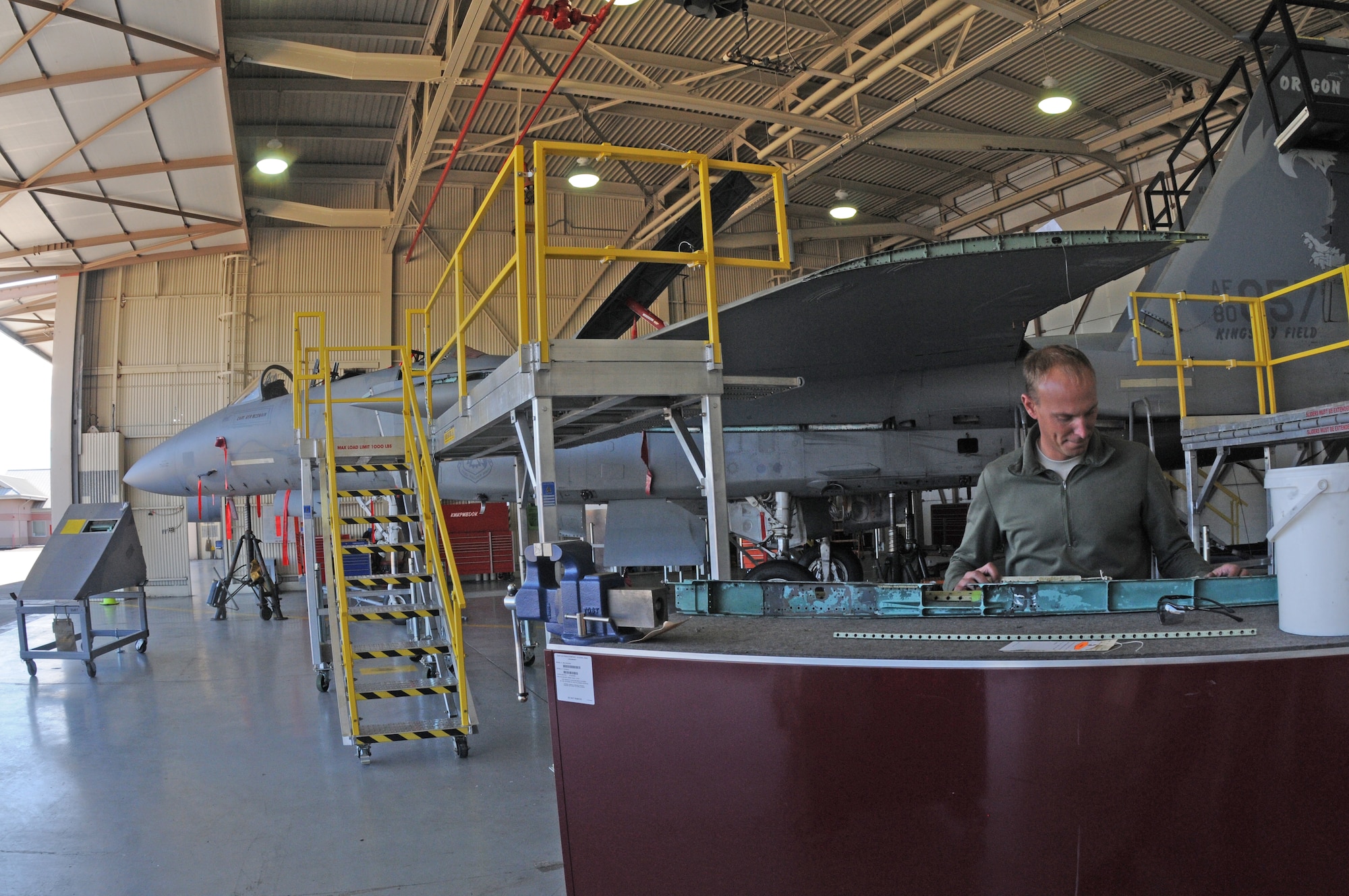 U.S. Air Force Staff Sgt. Andrew Lautenschlager, 173rd Fighter Wing F-15 crew chief, examines a crack found in a portion of the wing of the disassembled F-15 at Kingsley Field, in Klamath Falls, Ore. Oct. 16, 2014.  This aircraft is going through phase maintenance where the 173rd FW maintainers closely inspect the aircraft for cracks and other types of damage, verifying that the 30 plus year old aircraft is safe to fly.  (U.S. Air National Guard photo by Master Sgt. Jennifer Shirar/Released)    