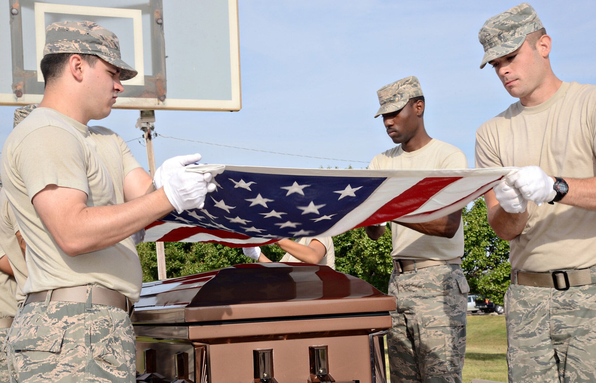 Senior Airmen Caleb Lay and Taylor Hill and Airman 1st Class Nicholas Poultney practice the precision movements of a flag-folding ceremony. (Air Force photo by Kelly White)