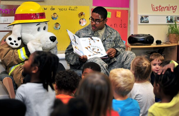 U.S. Air Force Senior Airman Theodore Willis, 100th Civil Engineer Squadron firefighter from Stockton, Calif., reads to children as part of Fire Prevention Week Oct. 16, 2014, at the child development center on RAF Mildenhall, England. RAF Mildenhall’s Fire Prevention Week was Oct. 12 to 17, 2014 and events included visits to local primary schools, reading to children at the CDC and grease pan fire demonstrations. (U.S. Air Force photo/Senior Airman Christine Griffiths/Released)