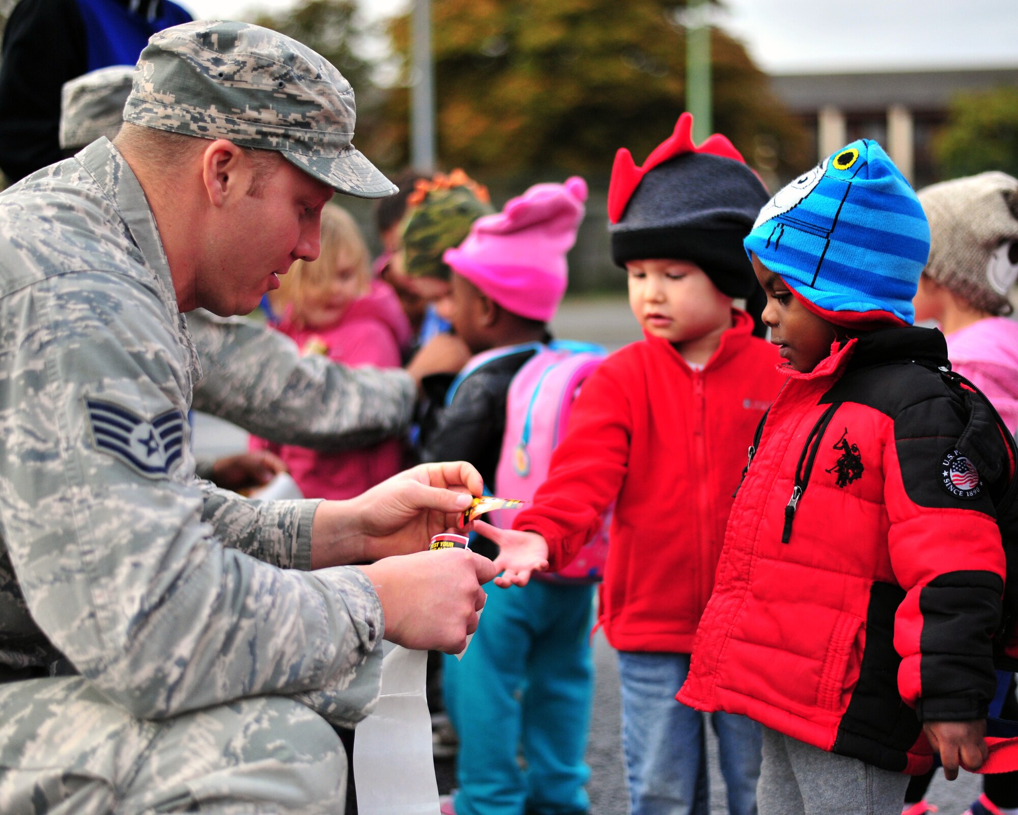 U.S. Air Force Staff Sgt. Zachary Edwards, 100th Civil Engineer Squadron firefighter passes out stickers to children as part of Fire Prevention Week Oct. 16, 2014, at the child development center on RAF Mildenhall, England. RAF Mildenhall’s Fire Prevention Week was Oct. 12 to 17, 2014 and events included visits to local primary schools, reading to children at the CDC and grease pan fire demonstrations. (U.S. Air Force photo/Senior Airman Christine Griffiths/Released)