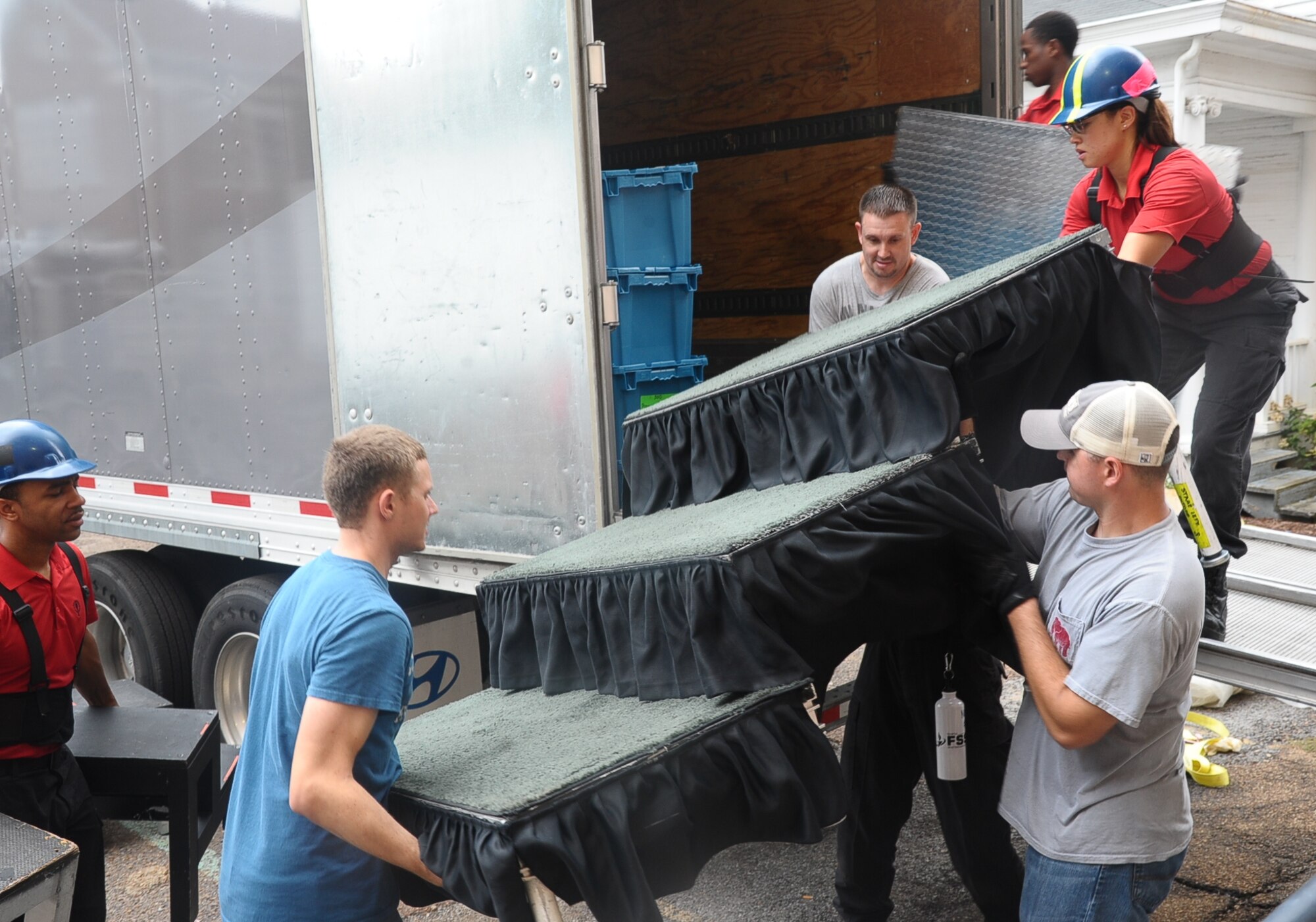 Several Airmen from Columbus Air Force Base help Tops in Blue personnel set up the performance stage Oct. 13 for the Tops in Blue performance Oct. 14 in the Mississippi University for Women Whitfield Auditorium. A total of 20 Team BLAZE Airmen volunteered their time to include setup, tear-down and ushering for the event. (U.S. Air Force photo/ Senior Airman Kaleb Snay)