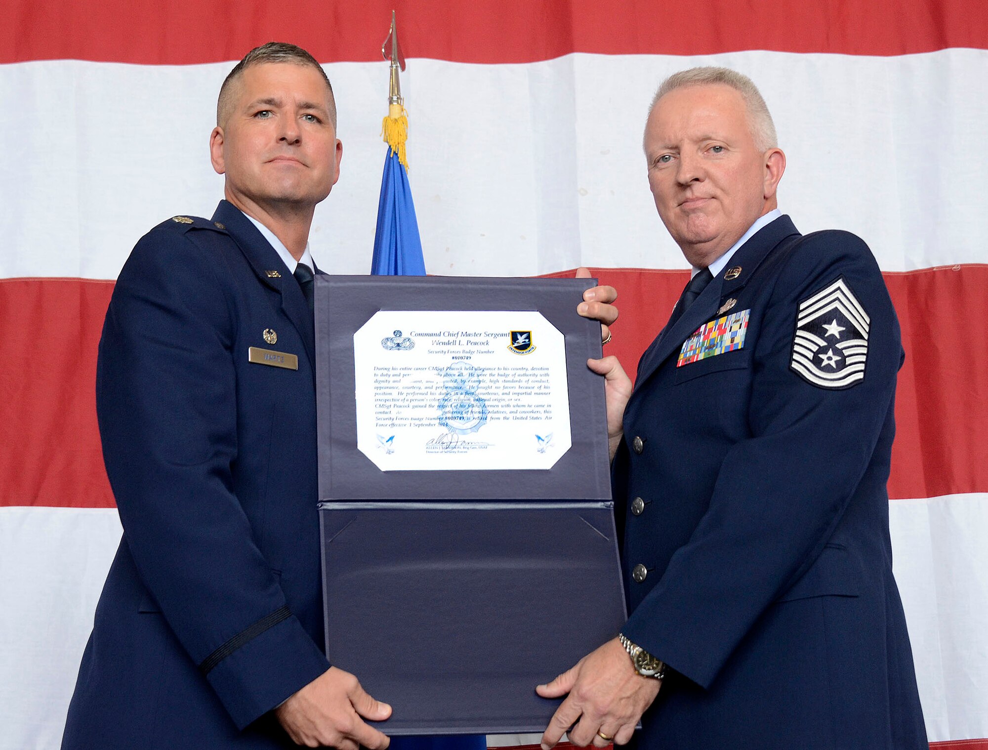 Col. Timothy Martz, 94th Security Forces commander, retires police badge number 010749 from Chief Master Sgt. Wendell Peacock, 94th Airlift Wing command chief, and the U.S. Air Force during his retirement ceremony at Dobbins Air Reserve Base, Aug. 2014. Peacock served as a security forces member for 30 years. (U.S. Air Force photo/Don Peek)