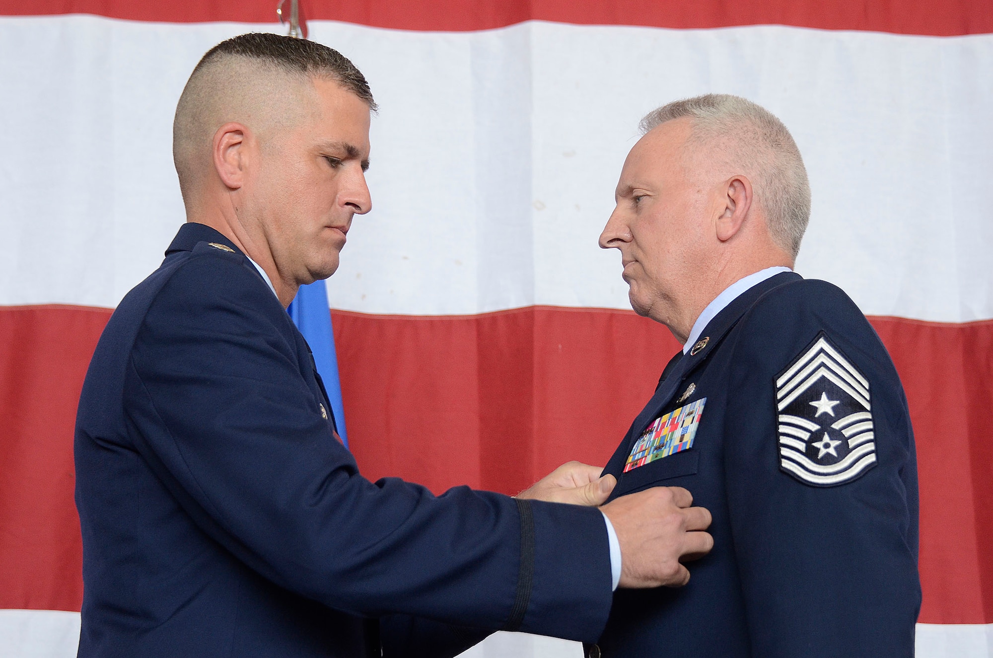 Col. Timothy Martz, 94th Security Forces commander, retires police badge number 010749 from Chief Master Sgt. Wendell Peacock, 94th Airlift Wing command chief, and the U.S. Air Force during his retirement ceremony at Dobbins Air Reserve Base, Aug. 2014. Peacock served as a security forces member for 30 years. (U.S. Air Force photo/Don Peek)