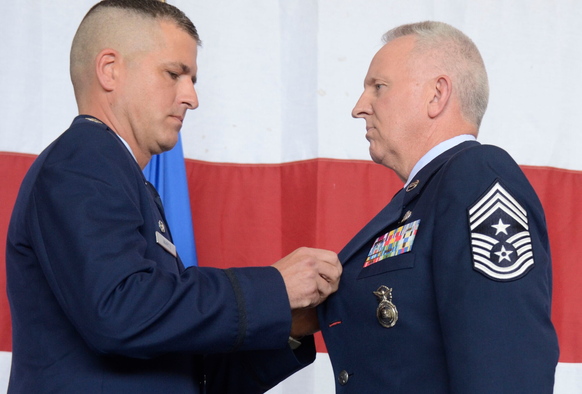 Col. Timothy Martz, 94th Security Forces commander, retires police badge number 010749 from Chief Master Sgt. Wendell Peacock, 94th Airlift Wing command chief, and the U.S. Air Force during his retirement ceremony at Dobbins Air Reserve Base, Aug. 2014. Peacock served as a security forces member for 30 years. (U.S. Air Force photo/Don Peek)