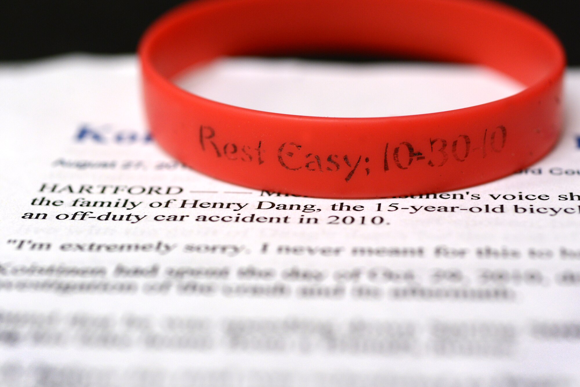 A memorial wristband rests upon a news article detailing the night 15-year-old Henry Dang died. Dang was killed riding a bicycle home by an off-duty police officer. Those who careered for him were affected forever. For those struggling with depression or if you notice someone struggling, please seek help from a chaplain, a supervisor or military and family life consultant. (U.S. Air Force photo/Airman 1st Class Ryan Conroy) 