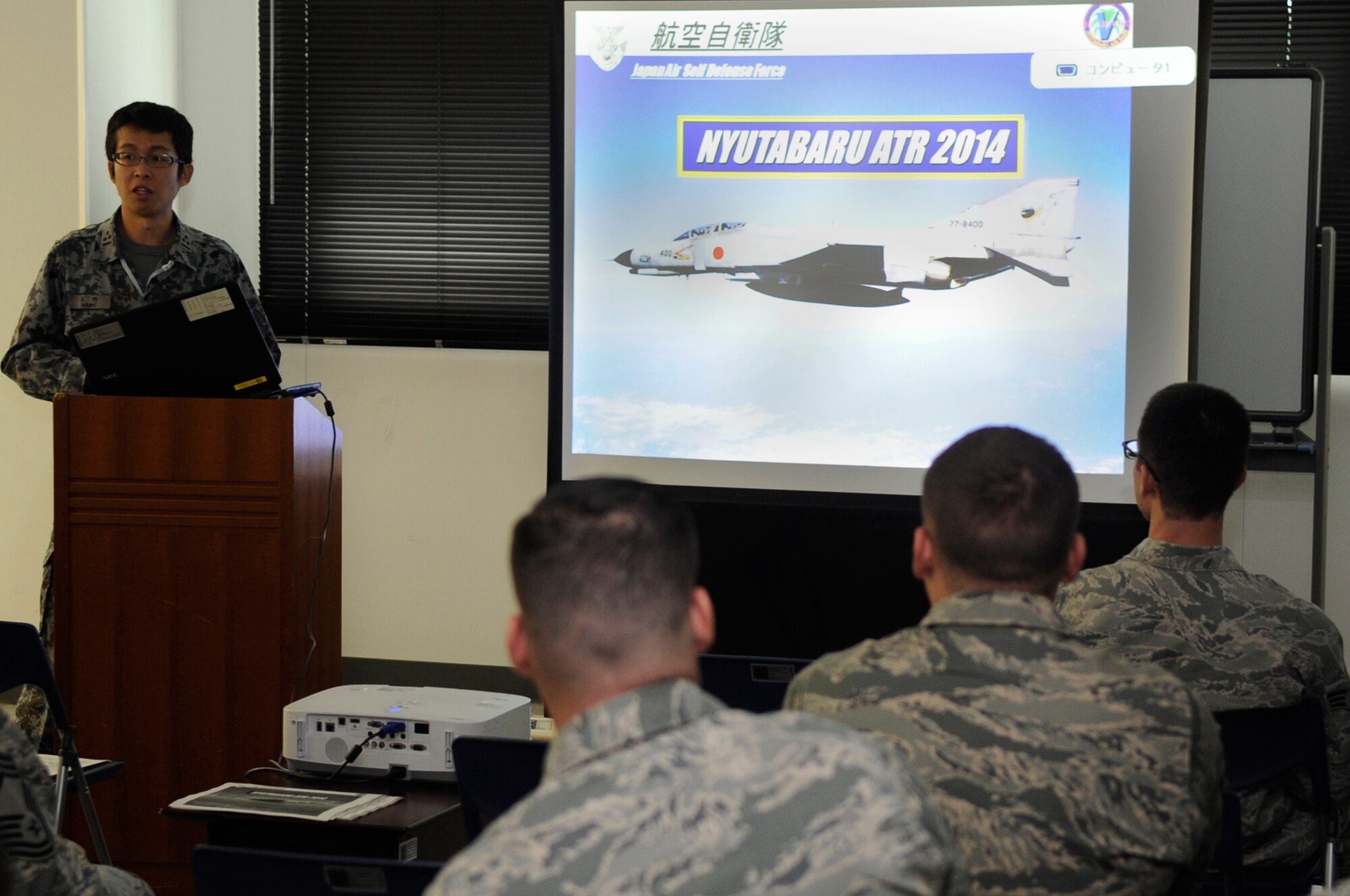 Japan Air Self-Defense Force Capt. Yuki Mizuno, 5th Air Wing Logistics Division chief of supply, briefs Airmen arriving from the 18th Wing on Nyutabaru Air Base, Japan, Oct. 16, 2014. This was part of an Aviation Training Relocation Program designed to increase operational readiness between U.S. and Japanese forces. (U.S. Air Force photo by Senior Airman Marcus Morris/Released)