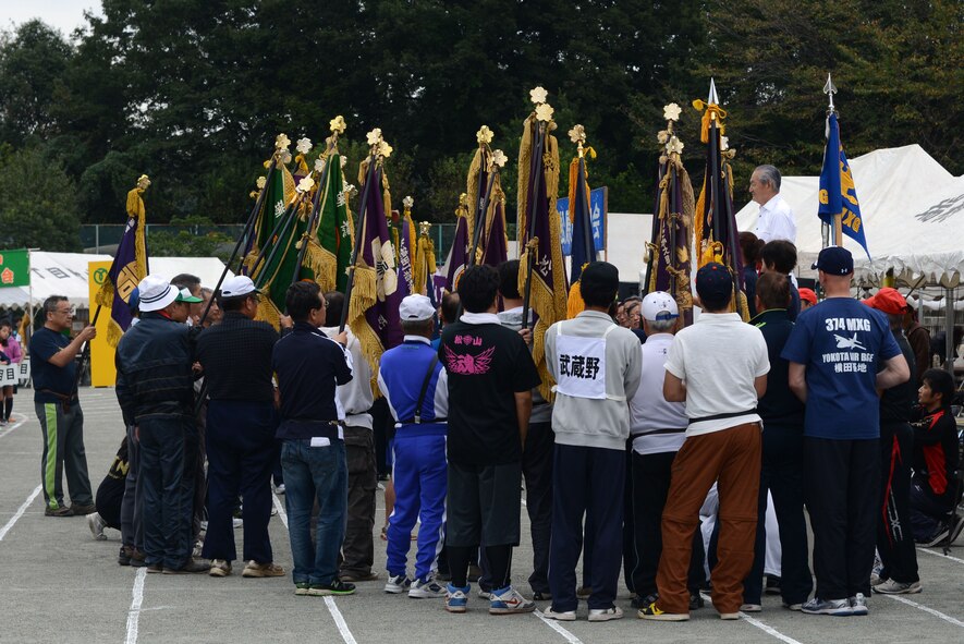 Flag holders from each team gather for a ceremony prior to the start of the sports day events in Mizuho, Japan, Oct. 12, 2014. The 374th Maintenance Group participated in the annual event as guests of the Mizuho Friendship Club. (U.S. Air Force photo by Senior Airman Desiree Economides/Released)