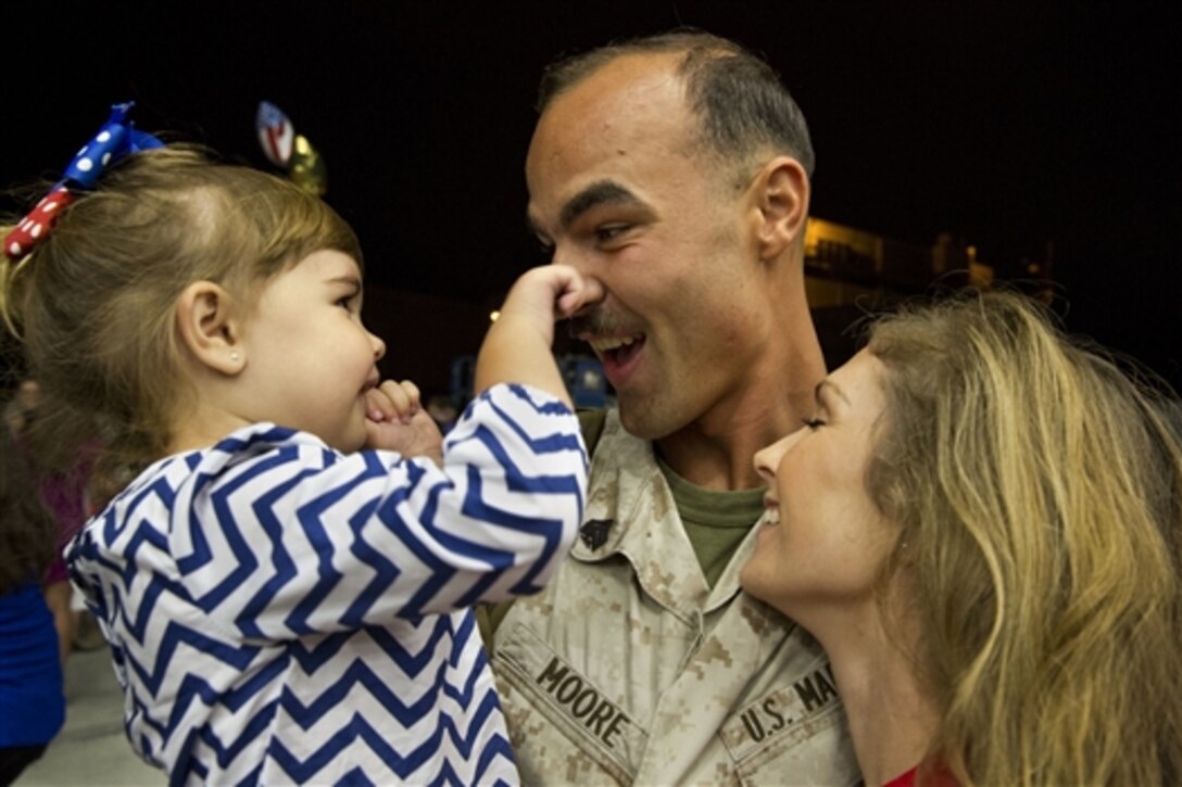 A Marine embraces loved ones as he returns home to Marine Corps Air Station New River, N.C., Oct. 12, 2014, after a nine-month deployment to Afghanistan. The Marine is assigned to Marine Medium Tiltrotor Squadron 261, 2nd Marine Aircraft Wing. The Marines from that unit aided the transition of security operations to Afghan forces. 