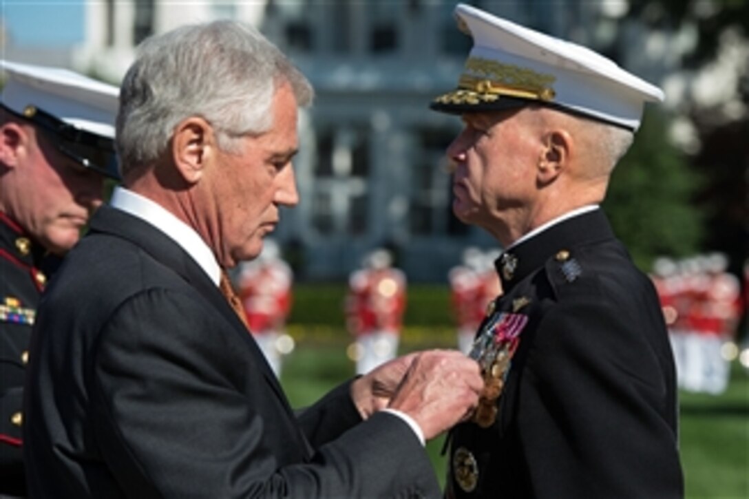 Defense Secretary Chuck Hagel pins a medal on outgoing Marine Corps Commandant Gen. James F. Amos during  a change-of-command ceremony on Marine Barracks in Washington, D.C., Oct. 17, 2014. Amos transfered command to Marine Corps Gen. Joseph F. Dunford Jr. 