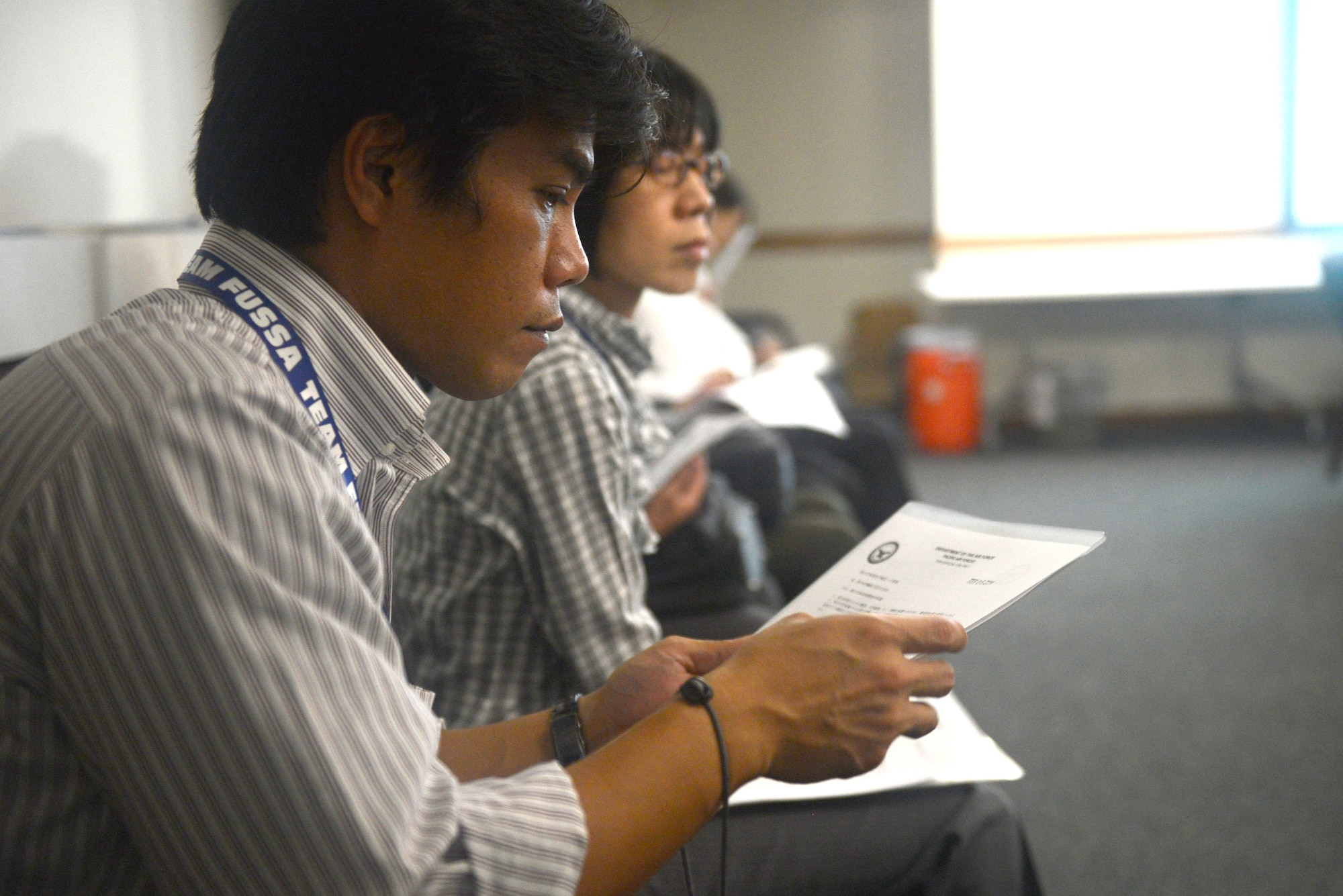 A city official reads an environmental management system packet at Yokota Air Base, Japan, Oct. 10, 2014. The officials also visited hazardous waste and material containment facilities as part of a tour showcasing their effectiveness. (U.S. Air Force photo by Airman 1st Class David C. Danford/Released)