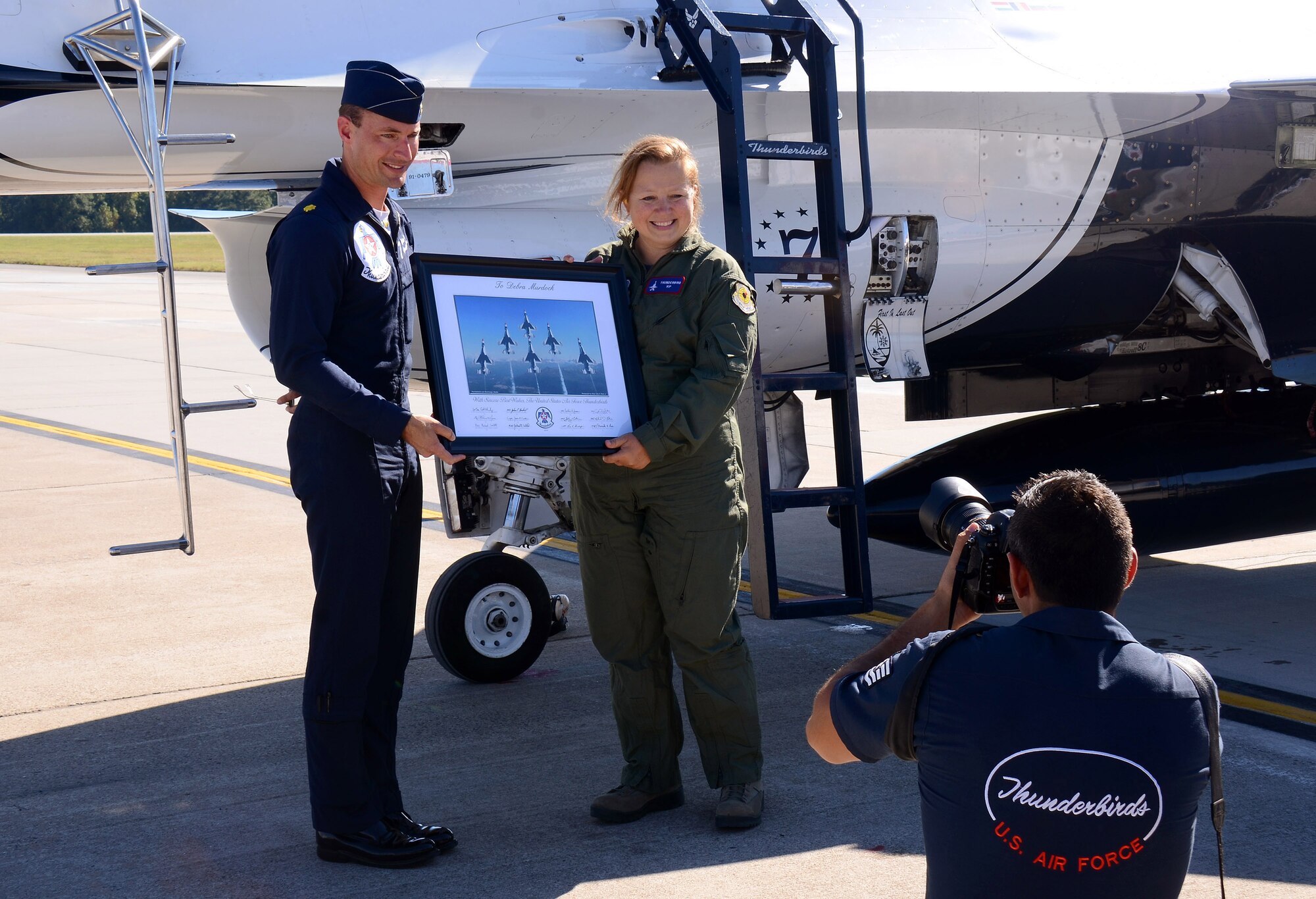 Maj. Tyler Ellison, Thunderbird #7, the squadron's operation officer, presents Mrs. Debra Murdock, principal of Cherokee High School in Canton, Georgia, with a framed and signed team photo after her Hometown Hero orientation flight at Dobbins Air Reserve Base, Georgia, Oct., 17. The USAF Air Demonstration Squadron Thunderbirds are using Dobbins as their base of operations for their performances at the Wings Over North Georgia Air Show this weekend at the Russell Regional Airport in Rome, Georgia . (U.S. Air Force photo/ Brad Fallin)