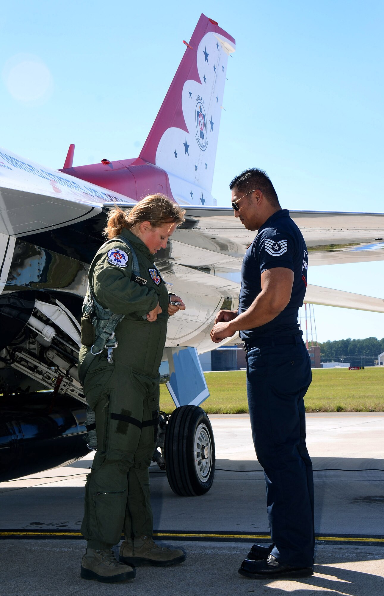 Mrs. Debra Murdock, principal for Cherokee High School in Canton, Georgia, gets assistance from Tech. Sgt. Mark Mira, dedicated crew chief for Thunderbird #8, in adjusting her harness for her Hometown Hero orientation flight at Dobbins Air Reserve Base, Georgia, Oct., 17. The USAF Air Demonstration Squadron Thunderbirds are using Dobbins as their base of operations for their performances at the Wings Over North Georgia Air Show this weekend at the Russell Regional Airport in Rome, Georgia . (U.S. Air Force photo/ Brad Fallin)