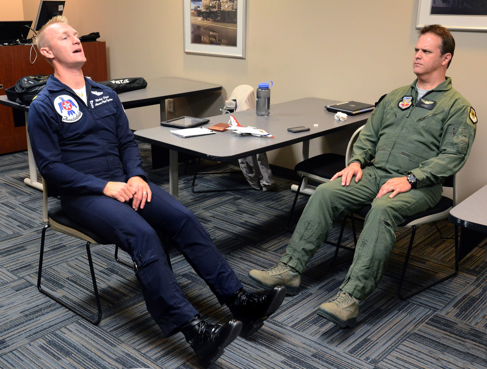 Maj. Michael Fisher, Thunderbirds advance pilot and narrator, demonstrates to Mr. Charles Atkeison, a CNN contributor, the proper body positioning in the unlikely event they will need to eject from the F-16D aircraft during his media orientation flight at Dobbins Air Reserve Base, Georgia, Oct., 17. The USAF Air Demonstration Squadron Thunderbirds are using Dobbins as their base of operations for their performances at the Wings Over North Georgia Air Show this weekend at the Russell Regional Airport in Rome, Georgia . (U.S. Air Force photo/ Brad Fallin)
