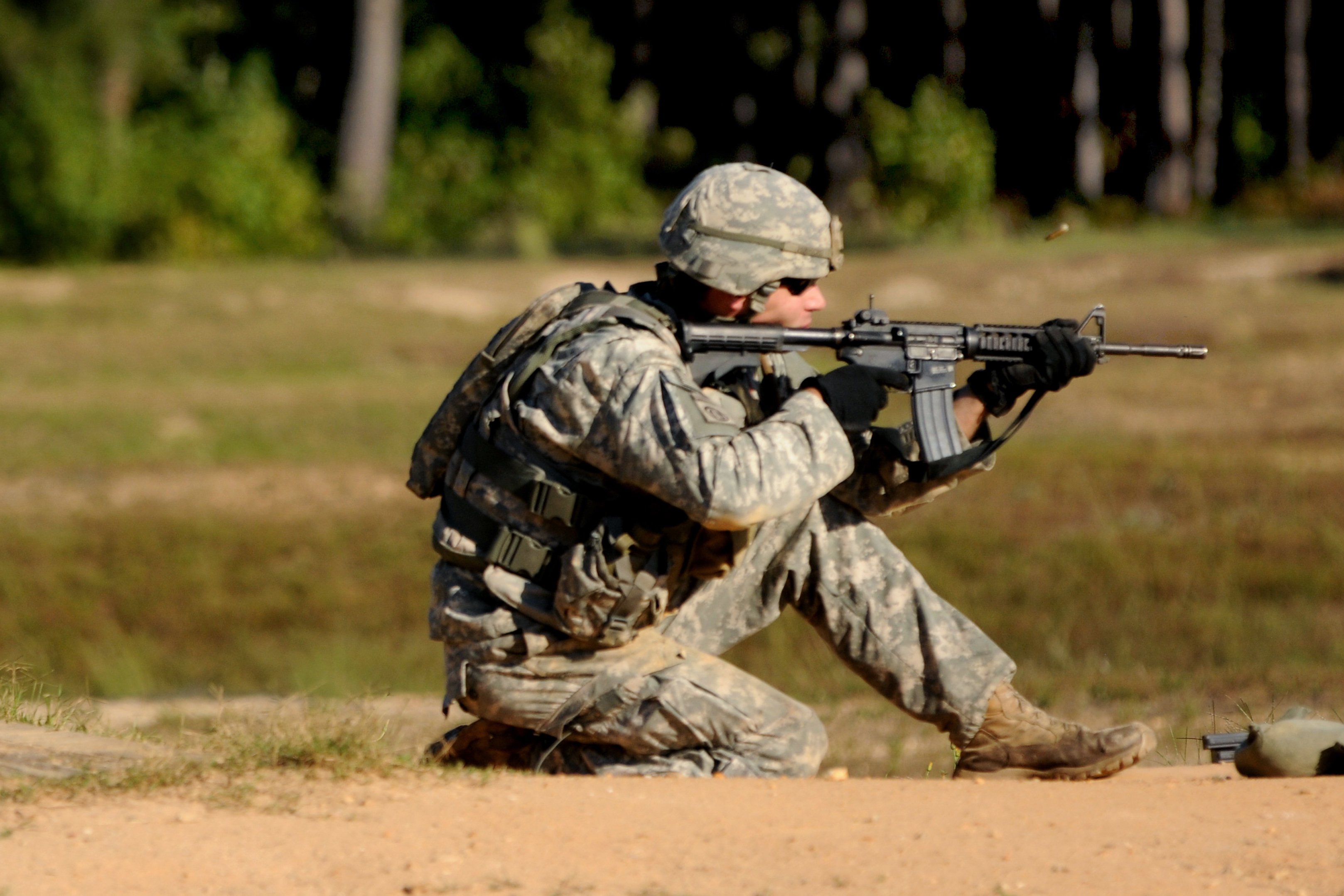 A soldier fires his M4 carbine rifle during a stress shoot range at the