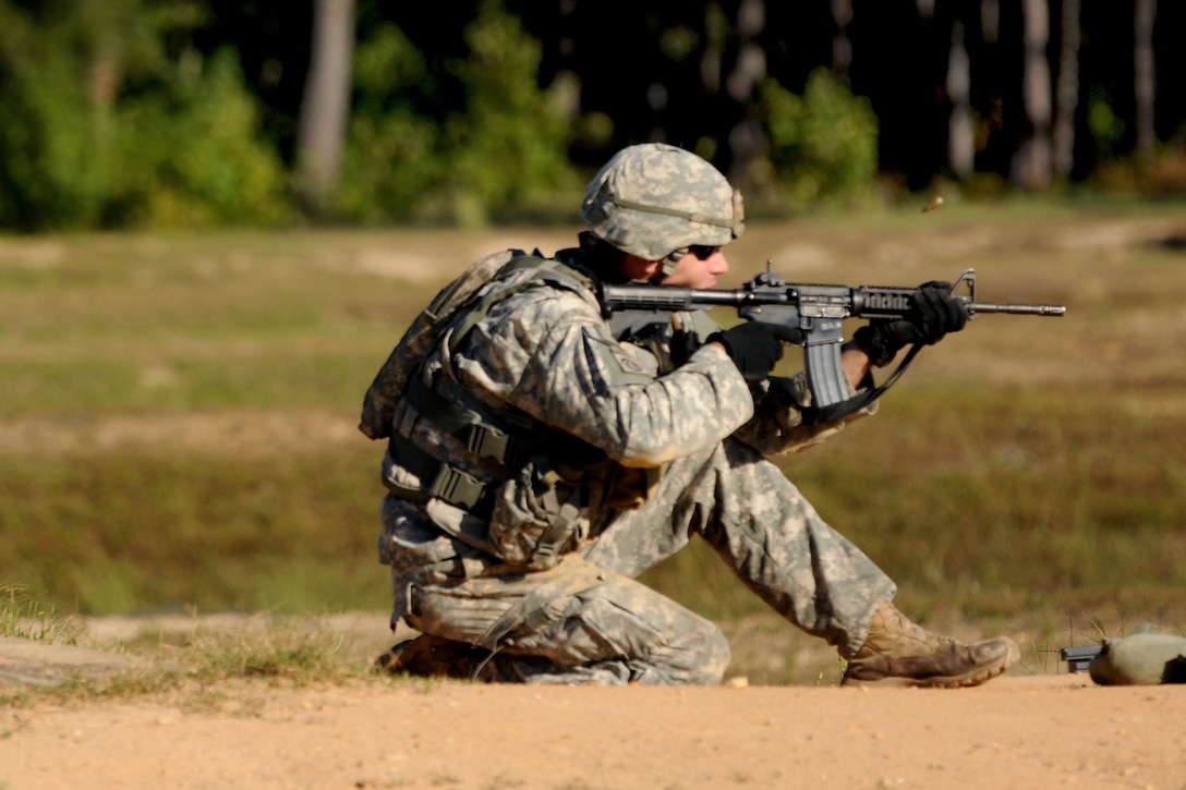 A soldier fires his M4 carbine rifle during a stress shoot range at the All-American Best Medic Competition on Fort Bragg, N.C., Oct. 6, 2014.