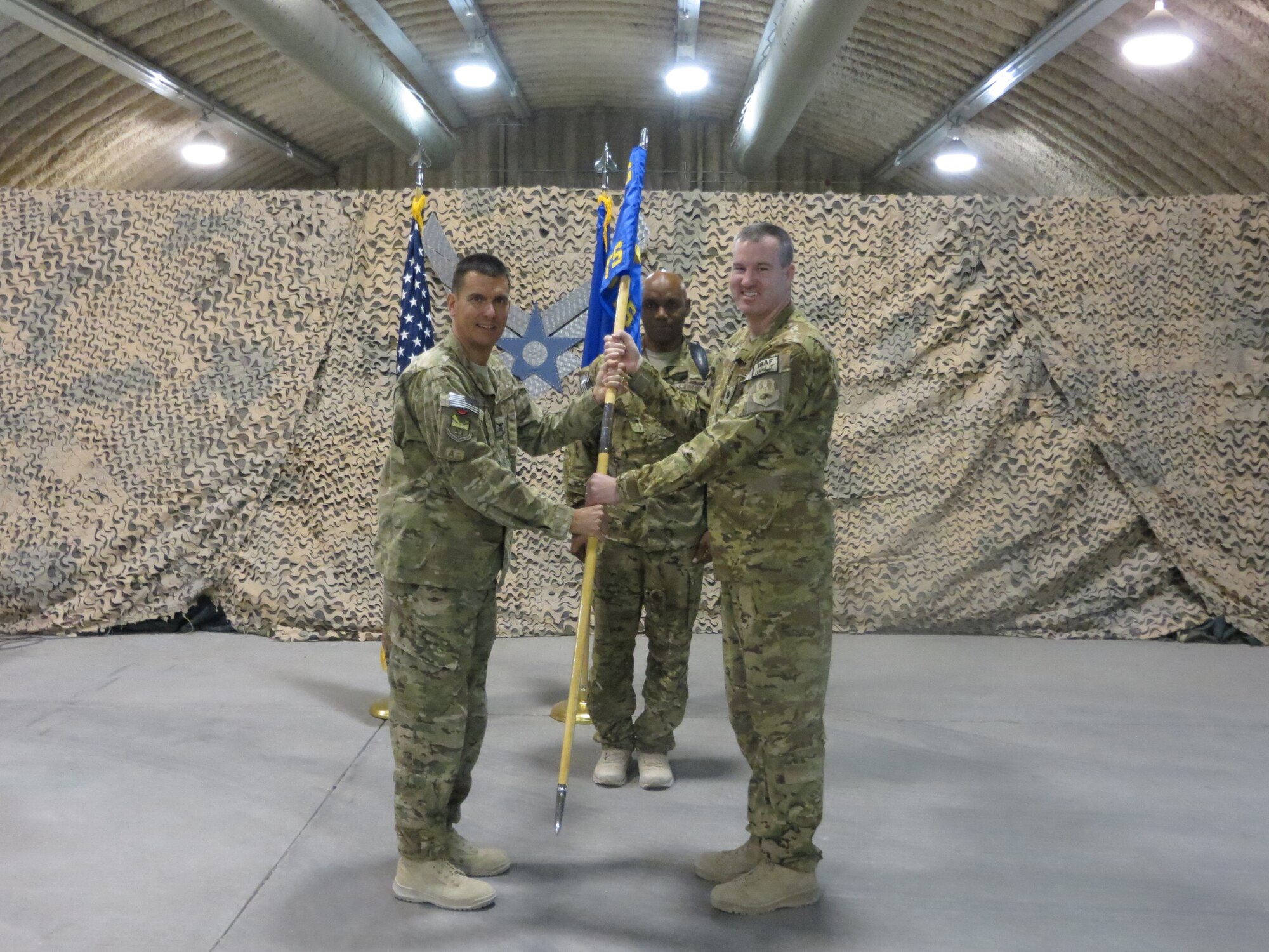 U.S.  Air Force Col. Rhude Cherry, 451st Air Expeditionary Group commander gives command of the 451st Expeditionary Operations Support Squadron to Lt. Col. James Mansard during an activation ceremony Sept. 30, 2014 at Kandahar Airfield, Afghanistan. Cherry activated the squadron when he uncased the 451 EOSS guidon. (U.S. Air Force courtesy photo/Released)