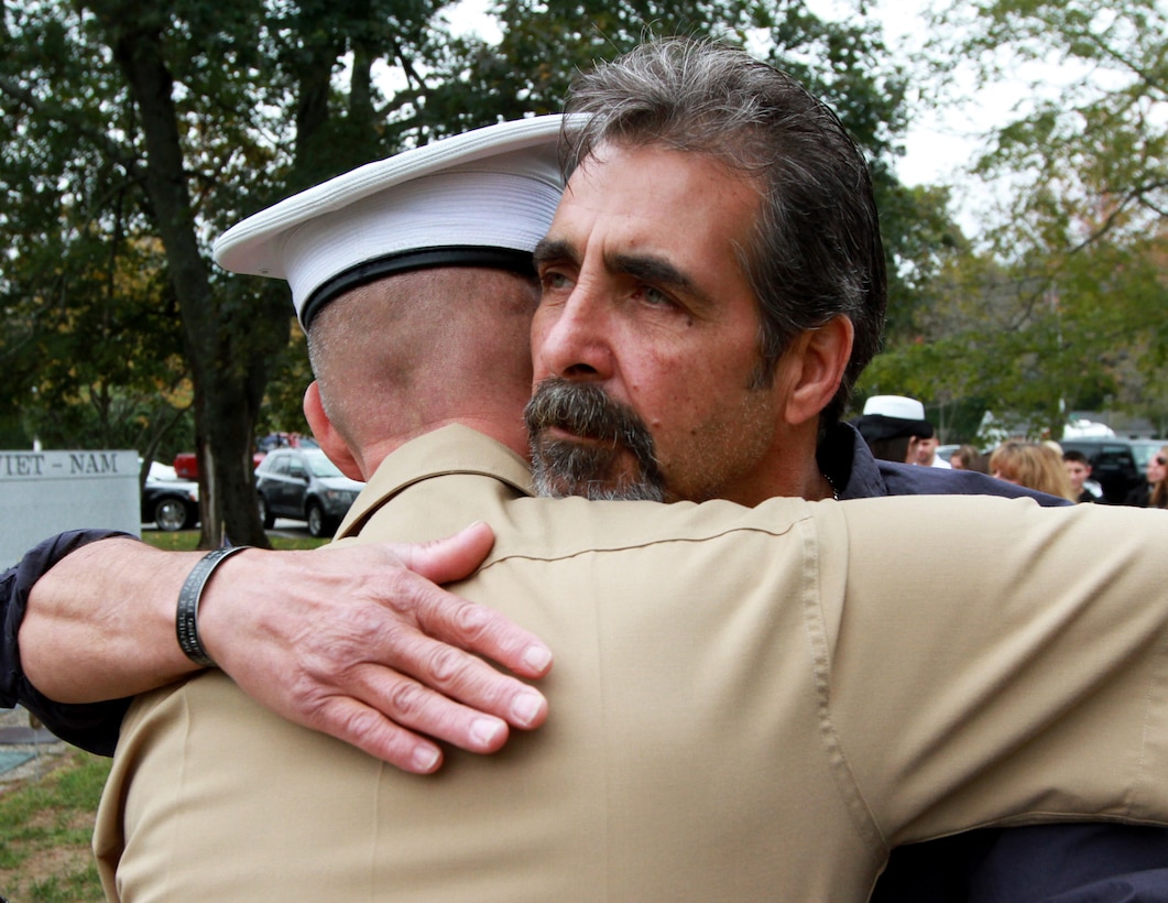 Mark Vasselian embraces Maj. James Nolan, Inspector-Instructor for Headquarters and Service Company and Weapons Company, , 1st Battalion, 25th Marine Regiment, following a ceremony where his son, Sgt. Daniel Vasselian, was posthumously awarded the Bronze Star Medal with Combat Distinguishing Device, Oct. 13, in front of the American Legion’s Lewis V. Dorsey Post 112 War Memorial in Abington, Mass. Daniel was posthumously awarded the Bronze Star Medal with Combat Distinguishing Device for combat actions while on his third deployment to Afghanistan. Daniel’s wife, Erin Vasselian, and parents, Karen and Mark Vasselian, each were presented with medals during the ceremony. Daniel was killed in action Dec. 23, 2013 in Helmand Province, Afghanistan. 
