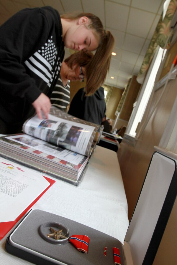 A table displays the Bronze Star Medal along with Sgt. Daniel Vasselian’s award citation and photos from his life Oct. 13, inside the American Legion’s Lewis V. Dorsey Post 112 in Abington, Mass. Daniel was posthumously awarded the Bronze Star Medal with Combat Distinguishing Device for combat actions while on his third deployment to Afghanistan. Daniel’s wife, Erin Vasselian, and parents, Karen and Mark Vasselian, each were presented with medals during the ceremony. Daniel was killed in action Dec. 23, 2013 in Helmand Province, Afghanistan. 