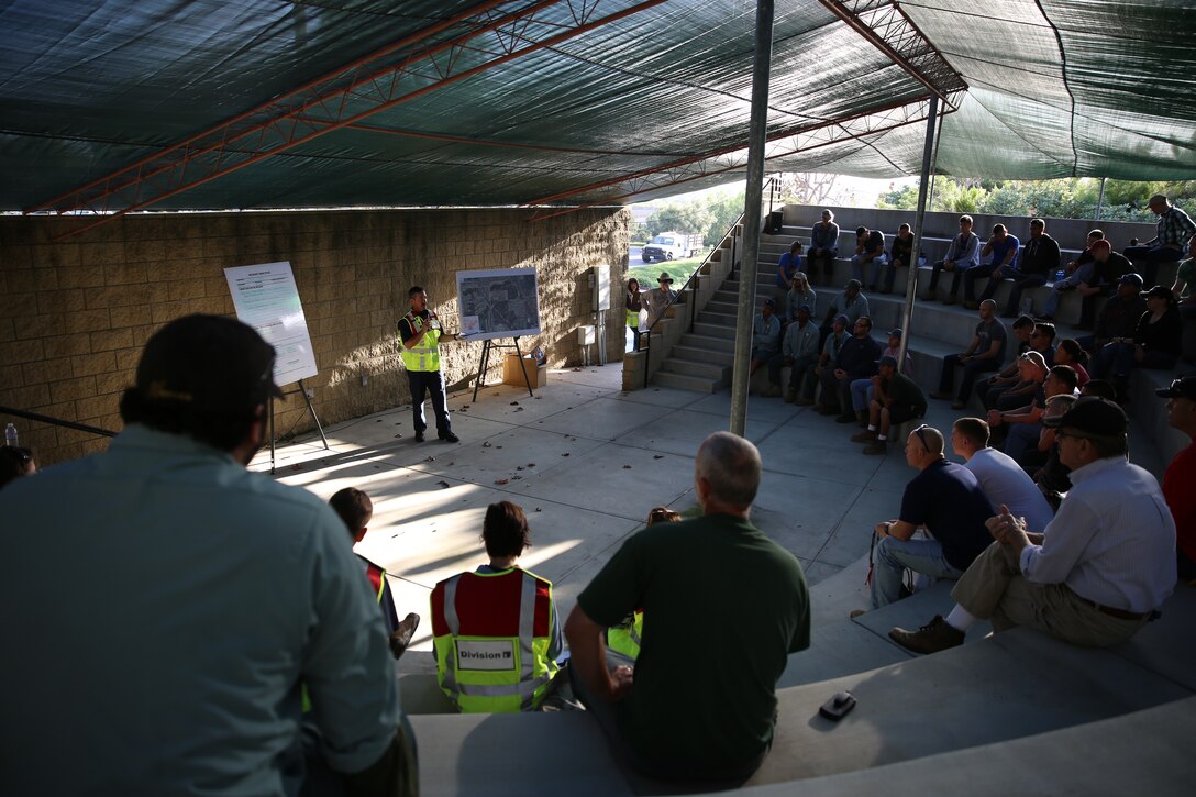 Huckle Berryman, a captain with the Carlsbad Fire Department, briefs Marines with Marine Light Attack Helicopter Squadron (HMLA) 169 and local volunteers before starting a cleanup at a fire-damaged area in Carlsbad, Calif., Oct. 18. Marines and local volunteers picked up debris left from a fire that damaged the area in May, 2014. 