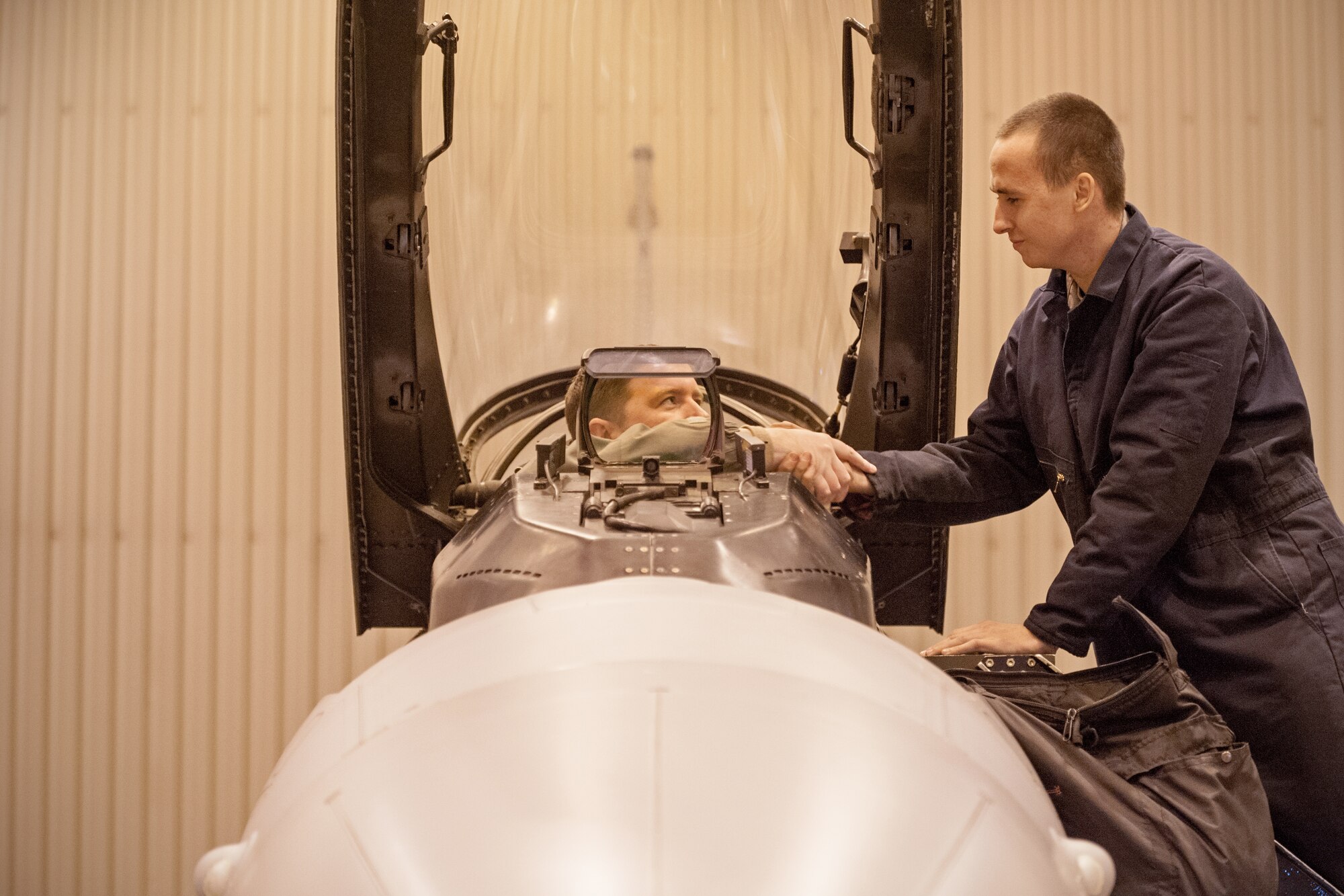 Major Garrett Dover, 35th Fighter Squadron pilot from Kunsan Air Base, Republic of Korea, shakes hands with Senior Airman Justin Alvarez, 8th Aircraft Maintenance Squadron crew chief, after a preflight check during RED FLAG-Alaska 15-1 at Eielson Air Force Base, Oct. 10, 2014. This field training exercise is focused on improving the combat readiness of U.S. and international forces and providing training for units preparing for air expeditionary force tasking. (U.S. Air Force Photo by Senior Airman Taylor Curry/Released)