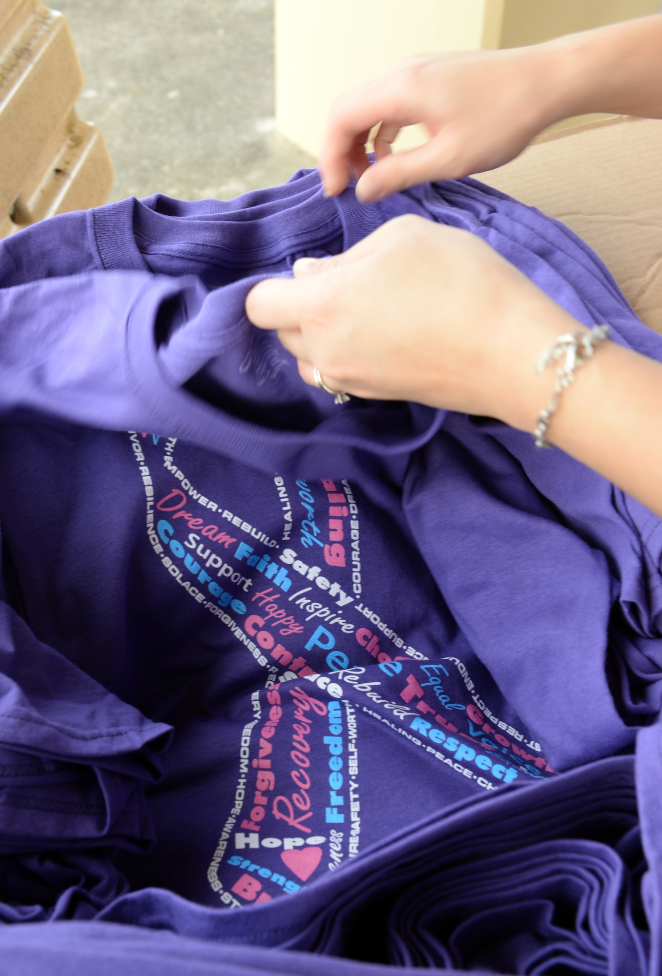 A member of the 36th Medical Group, family advocacy program, passes out t-shirts to participants in an Awareness Walk for Domestic Violence Awareness and Prevention month Oct. 16, 2014, on Andersen Air Force Base, Guam. The walk was one of three events hosted by the program and focused on the “Safe” aspect of the theme, “Relationships Should be Safe, Respectful and Positive”. (U.S. Air Force photo by Airman 1st Class Amanda Morris/Released)