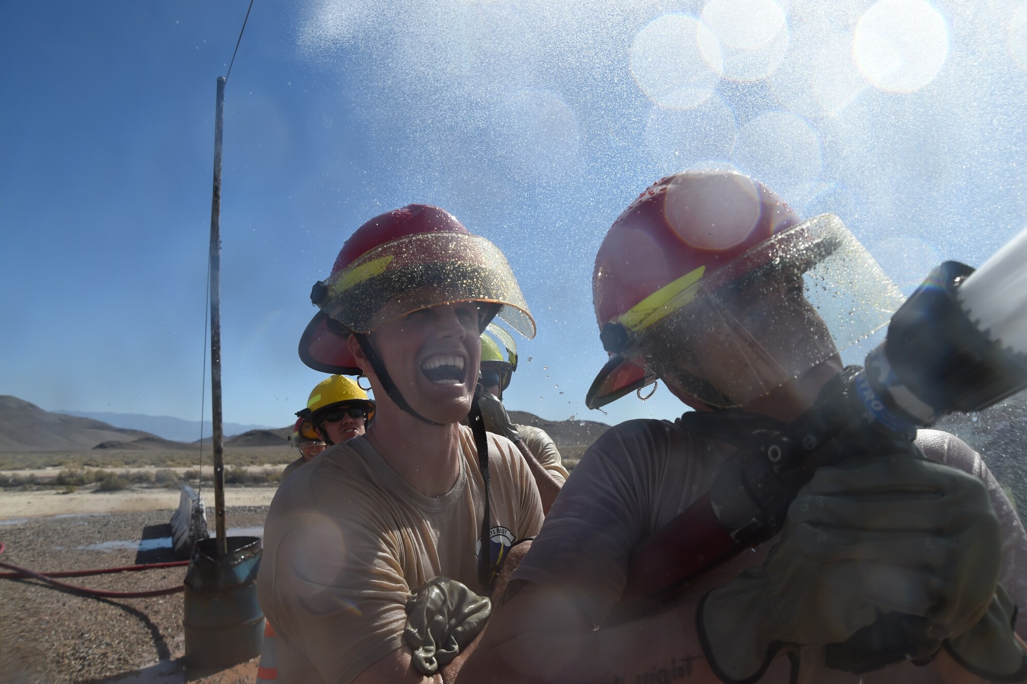 799th Security Forces Squadron team members battle against an opposing team during the water joust event for the championship title during a fire muster challenge at Creech Air Force Base, Nevada, Oct. 10, 2014. The 4th Annual Creech AFB Fire Muster Challenge concluded Fire Prevention Week, which promoted ‘Working Smoke Alarms Save Lives’ as this year’s theme. (U.S. Air Force Photo by Tech. Sgt. Shad Eidson/Released)