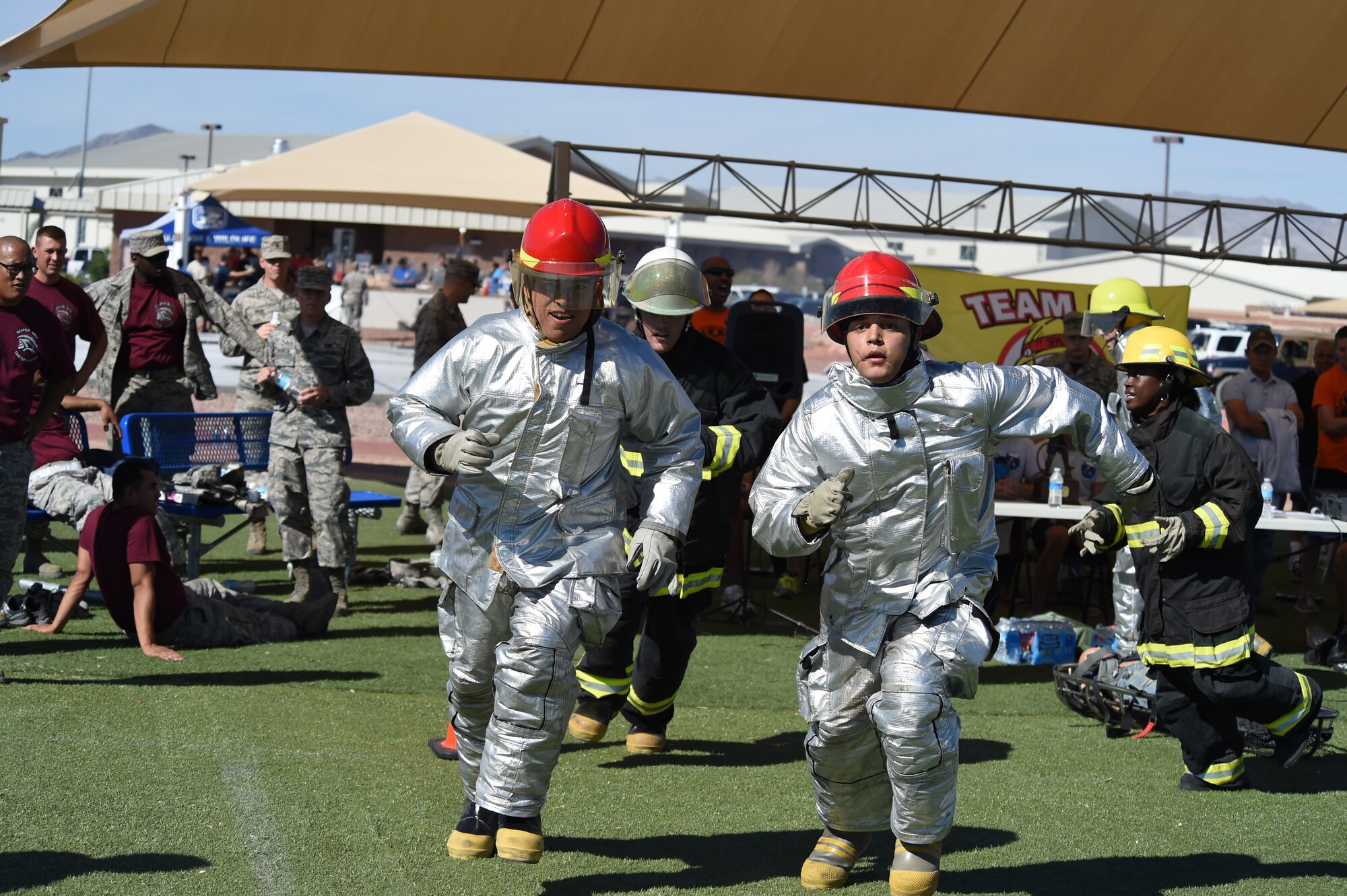 Tech. Sgt. David Yocom, left, and Senior Airman Quincey Knepper rush past fellow 432nd Aircraft Maintenance Squadron team members while racing to the next task during a fire muster challenge at Creech Air Force Base, Nevada, Oct. 10, 2014. Ten teams competed in the 4th Annual Creech AFB Fire Muster Challenge, which concluded a week-long campaign to spread fire safety awareness. (U.S. Air Force Photo by Tech. Sgt. Shad Eidson/Released)
