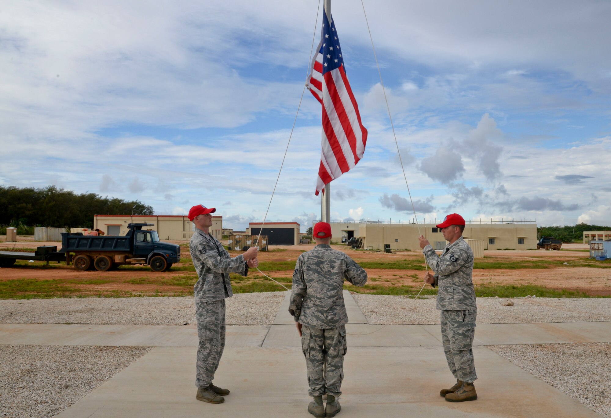 Airmen from the 554th RED HORSE Squadron raise the U.S.  flag Oct. 15, 2014, during the opening ceremony of Silver Flag on Northwest Field at Andersen Air force Base, Guam.  Silver Flag training is designed to setup operations at bare-base locations and features bed down planning, base recovery, command and control and airfield recovery. (U.S. Air Force photo by Staff Sgt. Robert Hicks/Released)