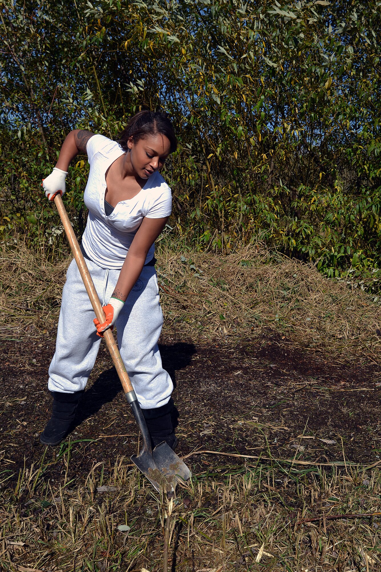 Senior Airman Anessah LaFlamme, 627th Force Support Squadron assignment technician, clears plant overgrowth from a baseball diamond during the Thurston County Day of Service event Oct. 16, 2014, at Pioneer Park in Tumwater, Wash. Airmen participating in the event performed a variety of jobs that included painting, demolition, brush removal, and graffiti removal. (U.S. Air Force photo/Senior Airman Jacob Jimenez)  