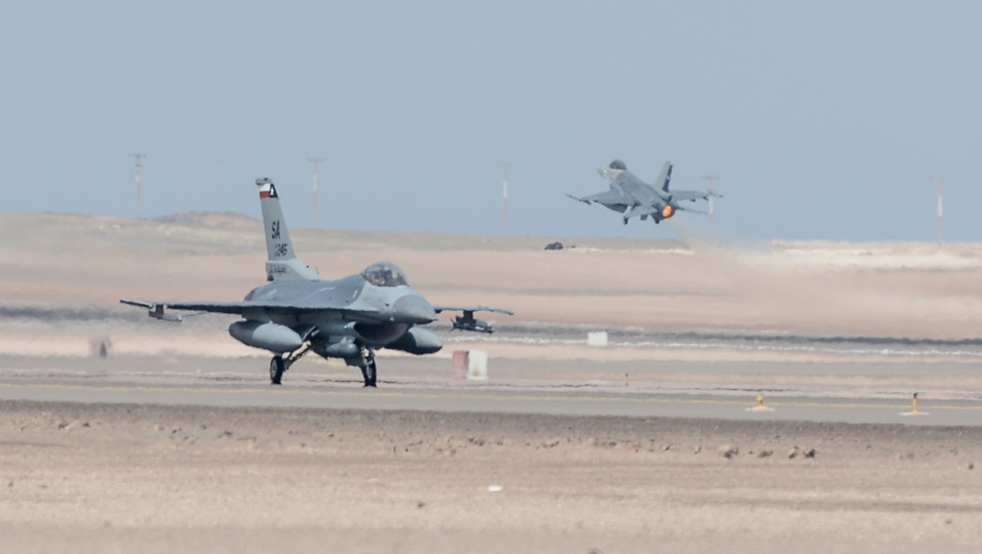 An F-16 from the Texas Air National Guard taxis as a Chilean F-16 takes off in the background at Cerro Moreno Air Base near Antofagasta, Chile. Aircraft from various nations participating in Salitre 2014 took part in large force employment exercises during the two-week long exercise which concluded Oct. 18. Salitre is a Chilean-led exercise where the U.S., Chile, Brazil, Argentina and Uruguay, focus on increasing interoperability between allied nations. Air National Guard photo by Senior Master Sgt. Miguel Arellano/released)