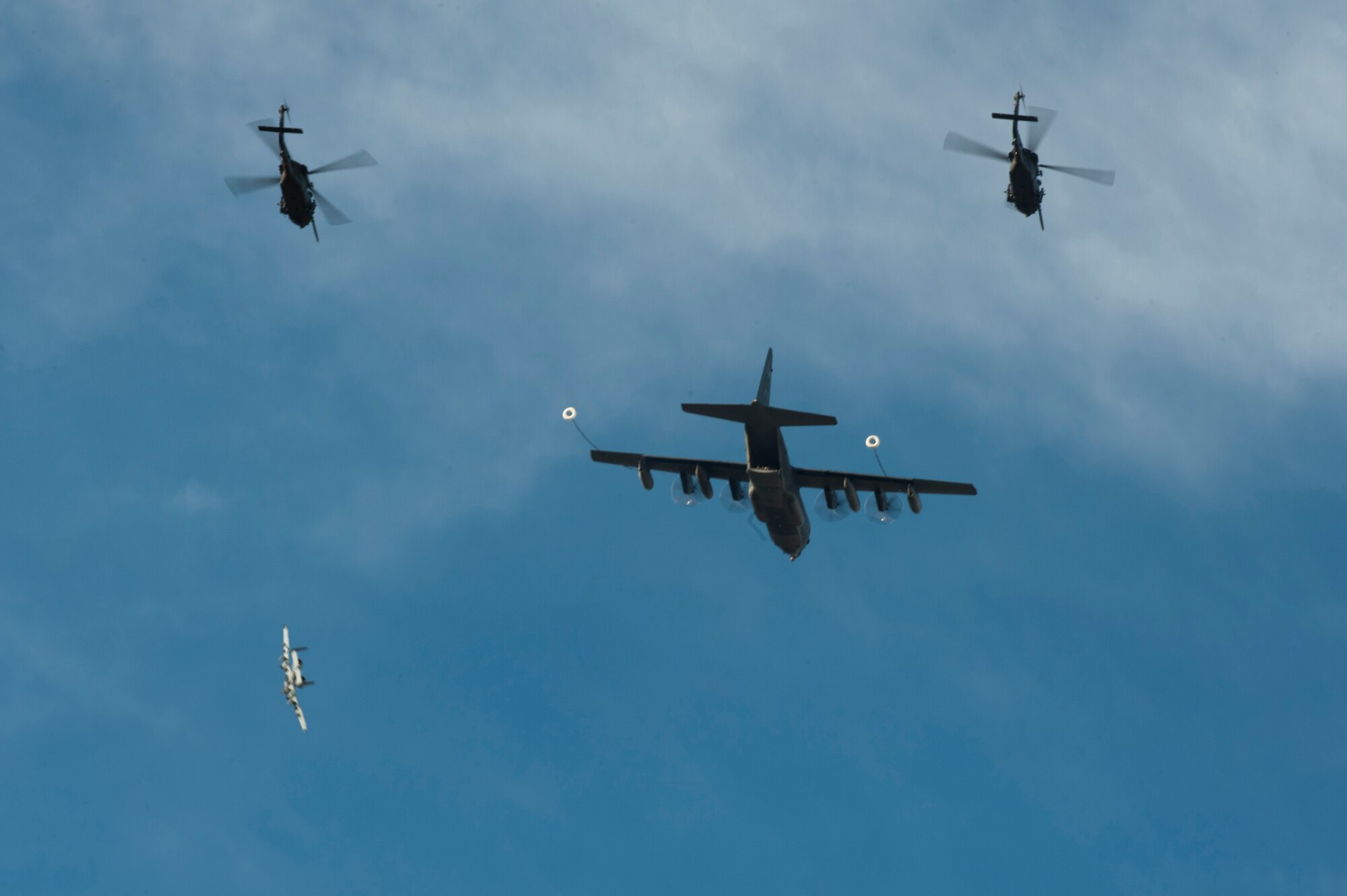 Aircraft from the 23d Wing perform an aerial refueling during a Combat Search and Rescue Task Force demonstration Oct. 17, 2014, at the U.S. Air Force Academy in Colorado Springs, Colo. The HH-60G Pave Hawks flew from Nellis Air Force Base, Nev., and the HC-130J Combat King II and A-10C Thunderbolt II flew from Moody AFB, Ga. (U.S. Air Force photo by Airman 1st Class Dillian Bamman/Released)