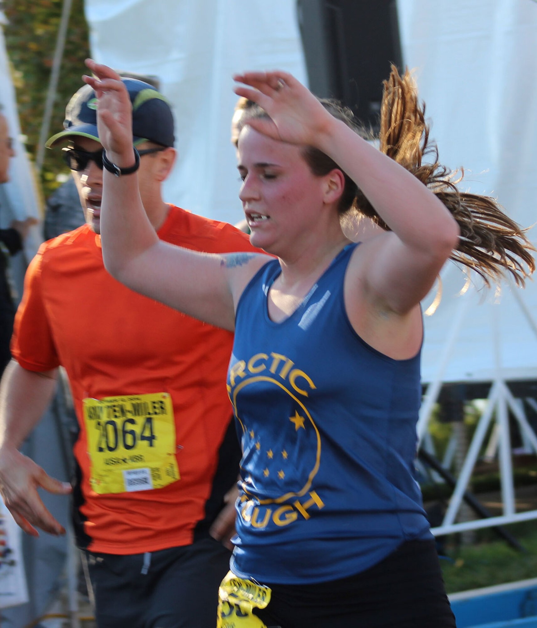 Pfc. Chelsea Sheuerman with Medical Department Activity-Alaska from Joint Base Elmendorf-Richardson, crosses the finish line of the Army Ten-Miler with raised arms Oct. 12 in Washington, D.C. Sheuerman was the youngest competitor to represent U.S. Army Alaska at the 30th annual event. (U.S. Army photo/Mary M. Rall)