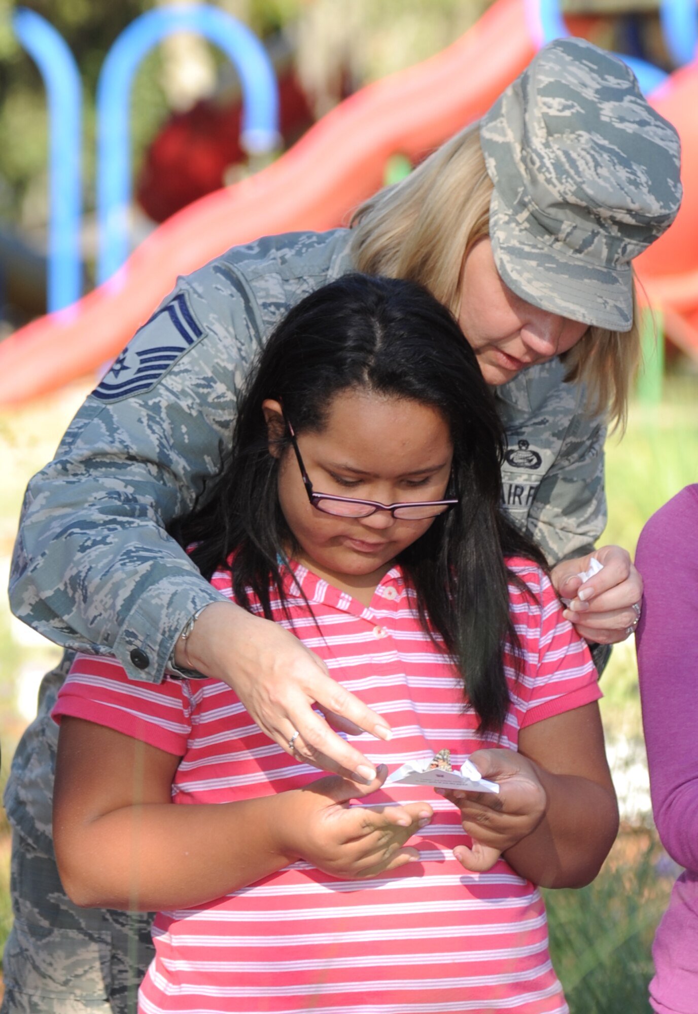Senior Master Sgt. Lisa Thomas, 81st Force Support Squadron, and her daughter release a butterfly during the opening of the Nature Explore Accessible Park at the marina park Oct. 16, 2014, at Keesler Air Force Base, Miss.  The new park is an area of nature-based learning and creative play for children with developmental and physical challenges, ages 12 and younger. The event also included the release of butterflies, ladybugs and flower planting. (U.S. Air Force photo by Kemberly Groue)