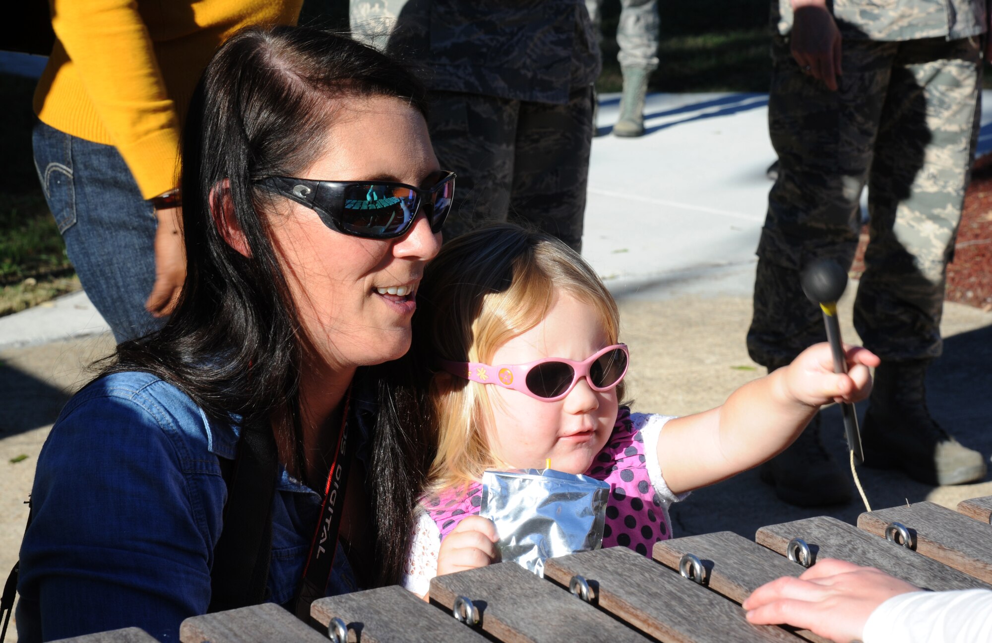 Natalie White, 81st Force Support marketing specialist, and her daughter play at the music  area during the opening of the Nature Explore Accessible Park at the marina park Oct. 16, 2014, at Keesler Air Force Base, Miss.  The new park is an area of nature-based learning and creative play for children with developmental and physical challenges, ages 12 and younger. The event also included the release of butterflies, ladybugs and flower planting. (U.S. Air Force photo by Kemberly Groue)
