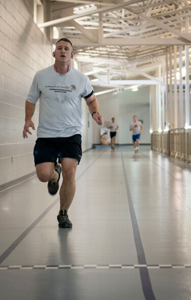 Capt. Craig Gilman, 23rd Bomb Squadron radar navigator, crosses the finish line during the Iron Airman Challenge on Minot Air Force Base, N.D., Oct. 10, 2014. The IAC is a test that consists of four events: push ups, sit ups, pull ups and a two-mile run. (U.S. Air Force photo/Airman 1st Class Sahara L. Fales)