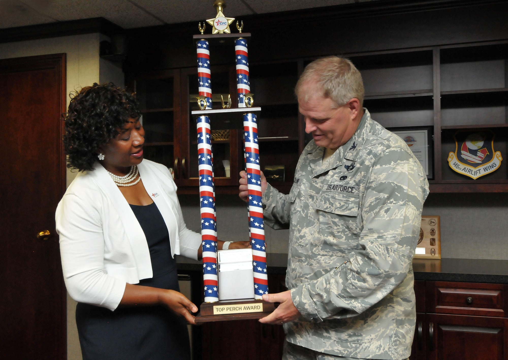 U.S. Air Force Col. Marshall C. Collins, commander, 145th Airlift Wing and retired Lt. Col. Rose Dunlap, representative for the Combined Federal Campaign (CFC), proudly display the 2013 Greater North Carolina CFC American Eagle “Top Perch” award. Collins accepted on behave of all military members and federal employees of the North Carolina Air National Guard that so generously contributed to local, national and international charities. The presentation was held at the North Carolina Air National Guard base, Charlotte Douglas Intl. Airport, June 17, 2014. (U.S. Air National Guard photo by Master Sgt. Patricia F. Moran, 145th Public Affairs/Released)