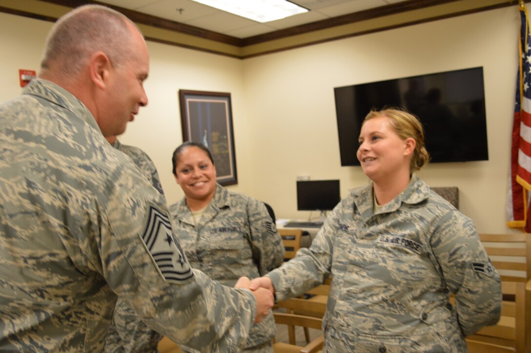 Air National Guard Command Chief Master Sgt. James Hotaling  greets Airman 1st Class Charlott LeMond of the Manpower, Personnel and Services Directorate as Staff Sgt. Amanda Finigan watches. The chief spent two days visiting and interacting with the enlisted force of the Continental United States North American Aerospace Defense Region – 1st Air Force (Air Forces Northern) and the 601st Air and Space Operations Center. (Photo by Mary McHale)