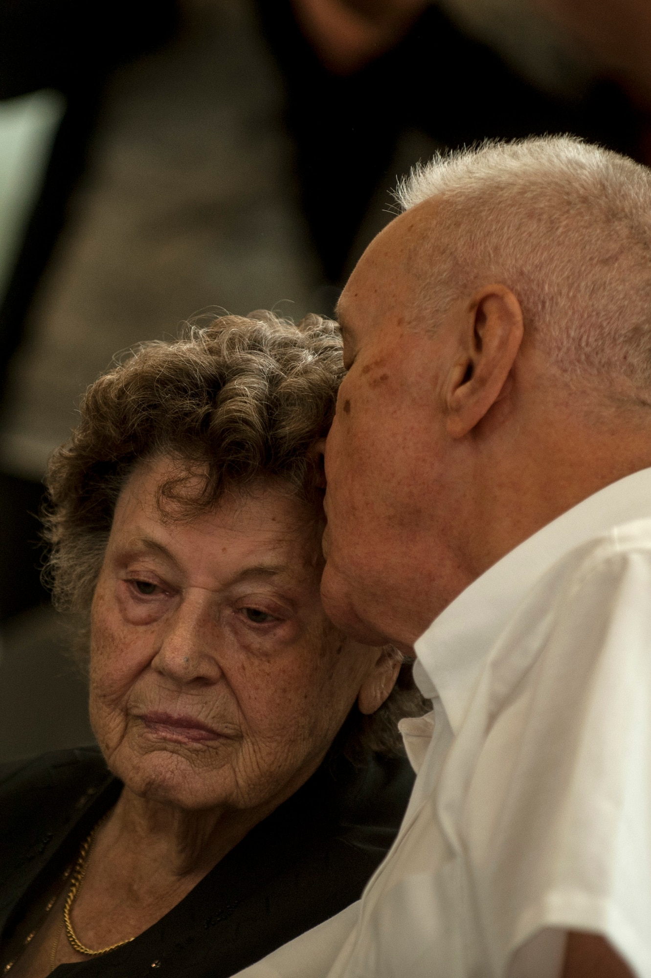 George Price, 52nd Force Support Squadron special events coordinator, kisses his wife, Hildi, during a dedication ceremony inside the Eifel Power Haus fitness center, Oct. 16, 2014, at Spangdahlem Air Base, Germany. The ceremony included the renaming of the gymnasium in Price’s honor as well as speeches from base leadership about his decades of service. (U.S. Air Force photo by Senior Airman Rusty Frank/Released)
