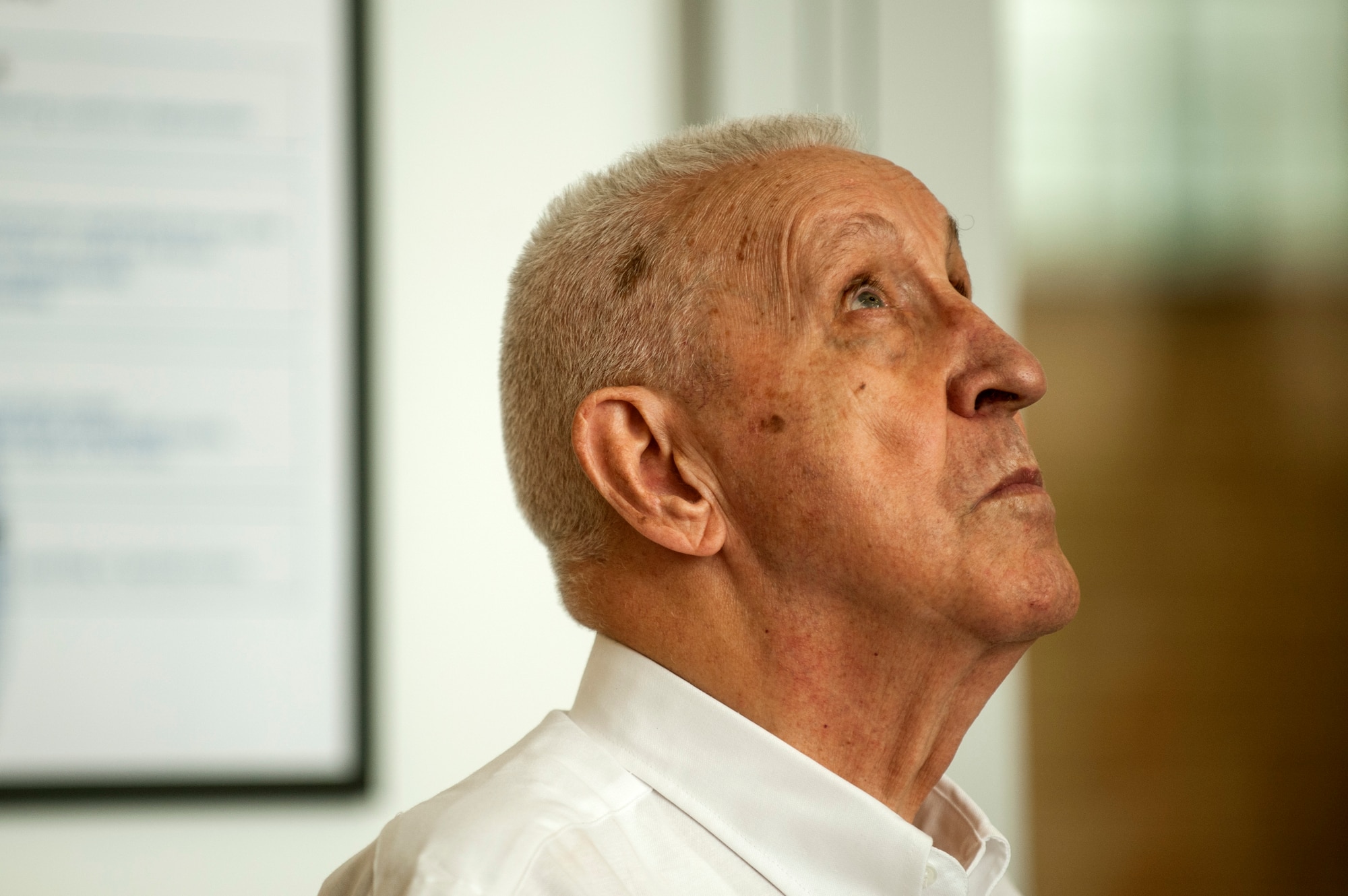 George Price, 52nd Force Support Squadron special events coordinator, looks up during his speech at a dedication ceremony in his honor inside the Eifel Power Haus fitness center Oct. 16, 2014, at Spangdahlem Air Base, Germany. Price thanked all the people who helped him throughout his career including his son Robin Price, who passed away in July 2014. (U.S. Air Force photo by Senior Airman Rusty Frank/Released)