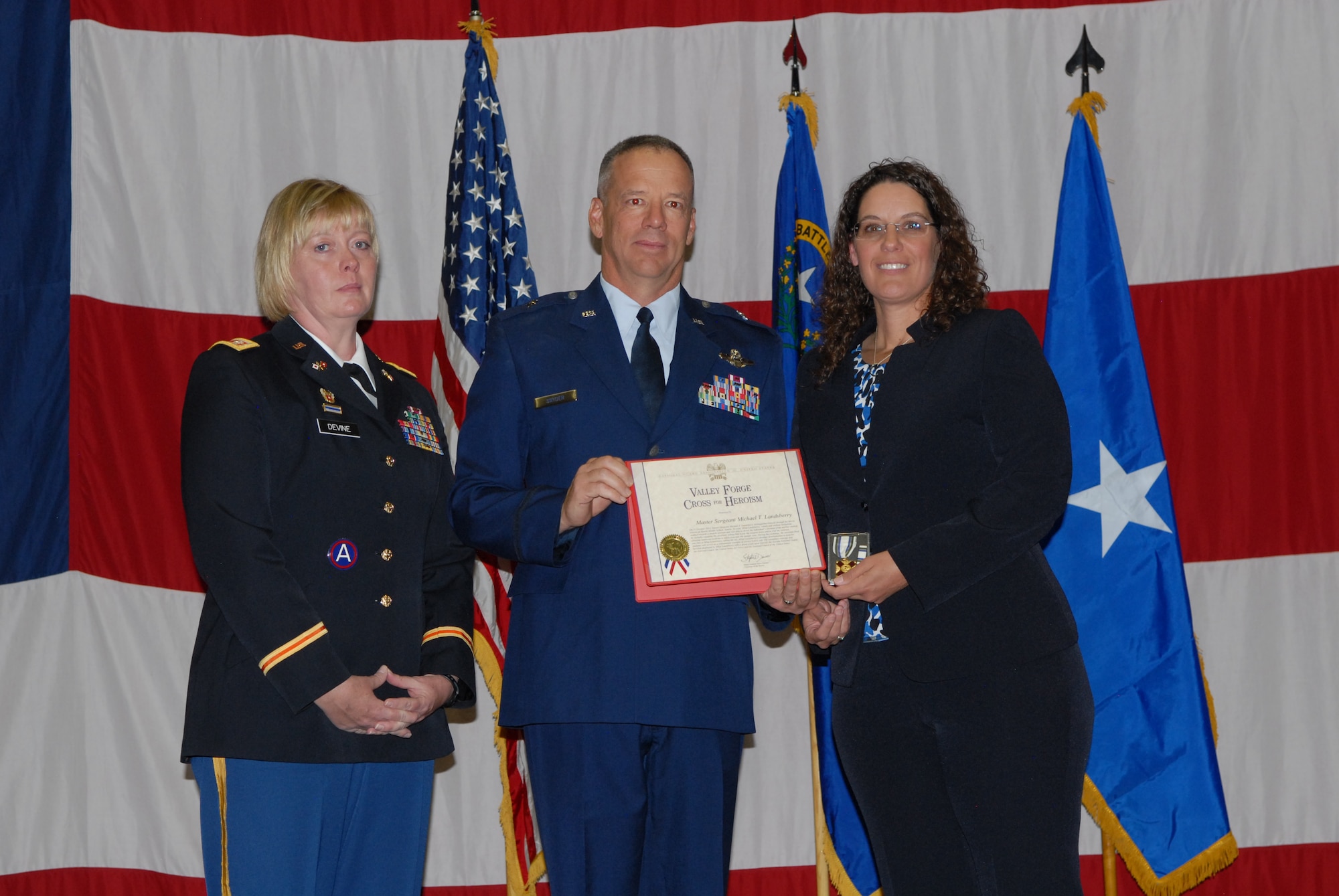 Nevada Army National Guard Lt. Col. Mary Devine (left), and Nevada Air National Guard Brig. Gen. David Snyder (center) present Sharon Landsberry with the National Guard Association's Valley Forge Cross for Heroism during a ceremony on Sunday at the Reno-Sparks Convention Center.  Sharon's late husband, Master Sgt. Michael Landsberry, gave his life to save his students during a shooting incident on 21 Oct. 2013, at Sparks Middle School.  U.S. Air Force photo by Senior Airman Ashif Halim. (RELEASED).
