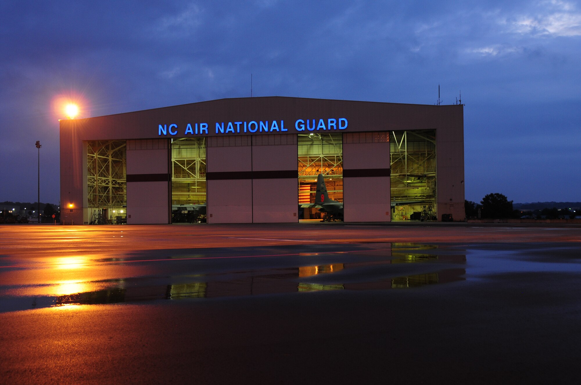 Proper lighting is a key factor for the 145th Maintenance Squadron (MXS), as airmen work on two C-130 Hercules aircraft at the North Carolina Air National Guard base, Charlotte Douglas Intl. Airport, Sept. 19, 2014. 145th Civil Engineer Squadron (CES) maintains the buildings, structures and utilities on the base but also must comply with the Department of Defense Energy Action Plan. To sustain both missions, 145th CES replaced 11 existing inefficient 1000-watt lights with 400 watt induction lamps. This initiative contributed to an annual savings of more than $1,600.00 for the 145th Airlift Wing. (U.S. Air National Guard photo by Master Sgt. Patricia F. Moran, 145th Public Affairs/Released)