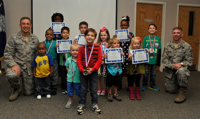 Colonel John Lamontagne, 437th Airlift Wing commander, and Chief Master Sgt. Shawn Hughes, 437th AW command chief, spend time with children of deployed and recently deployed service members following a "Little Heroes" ceremony Oct. 16, 2014, at the Airman and Family Readiness Center on Joint Base Charleston, S.C. The ceremony honored 13 children ages 3 to 14. (U.S. Air Force photo/Staff Sgt. Renae Pittman)