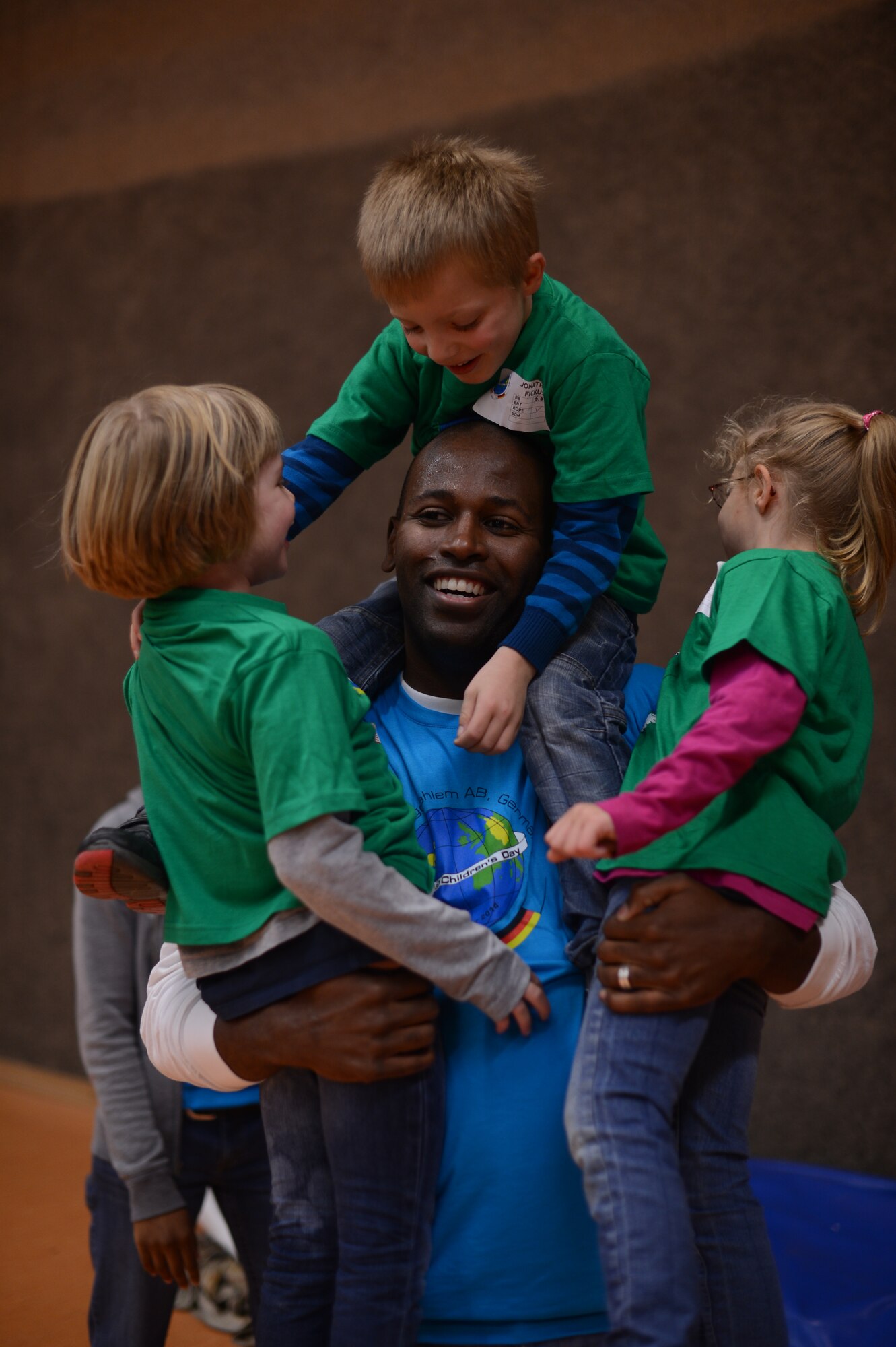 U.S. Air Force Staff Sgt. Darrell Lewis, 52nd Logistics Readiness Squadron inbound traffic management office technician from Milwaukee, plays with children from St. Martin School in the Skelton Memorial Fitness Center on Spangdahlem Air Base, Germany, Oct. 16, 2014. More than 250 volunteers from across the base participated in the event. (U.S. Air Force photo by Senior Airman Gustavo Castillo/Released) 