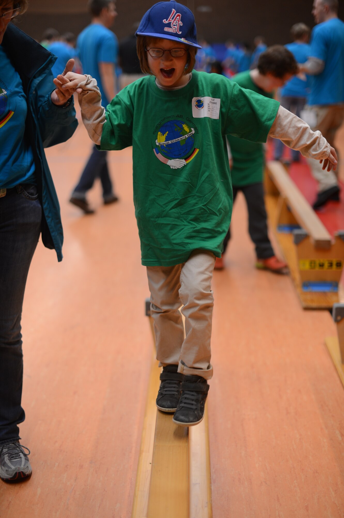 Julie Johanns, 6, a child from St. Martin School walks across a balance beam in the Skelton Memorial Fitness Center on Spangdahlem Air Base, Germany, Oct. 16, 2014. Members of the Spangdahlem community host this event to strengthen community relations by providing a day where the mentally or physically challenged children of St. Martin School can participate in a day of games, food and fun. (U.S. Air Force photo by Senior Airman Gustavo Castillo/Released) 
