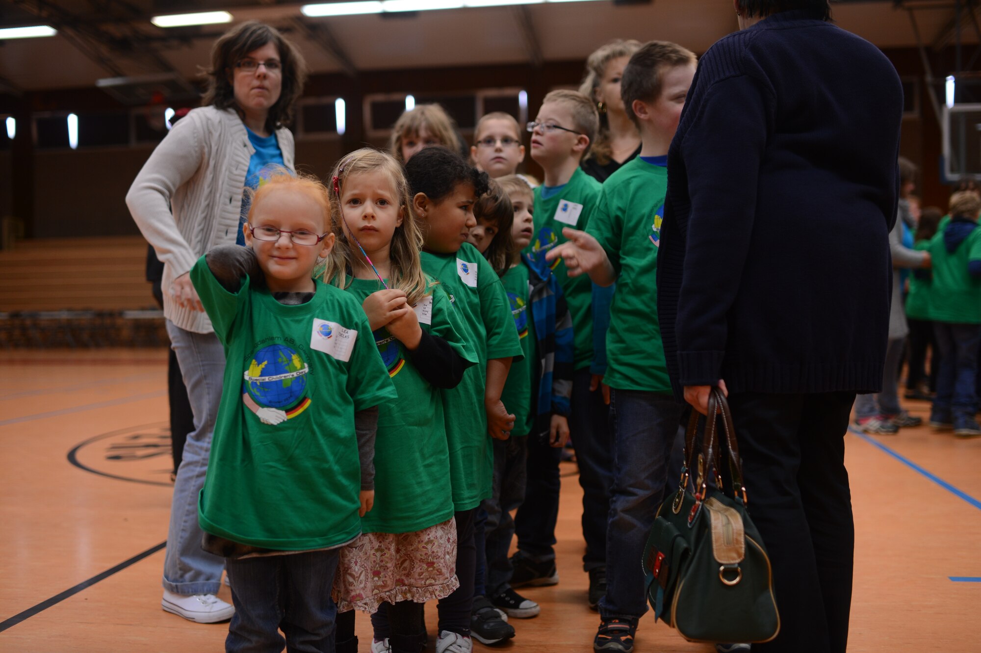 Children from St. Martin School line up before being assigned a “buddy” in the Skelton Memorial Fitness Center on Spangdahlem Air Base, Germany, Oct. 16, 2014. The base volunteers served as a child's "buddy," which entails one of two or three people assigned to every child aiding them in completing the sporting activities and keeping their scorecard. (U.S. Air Force photo by Senior Airman Gustavo Castillo/Released) 